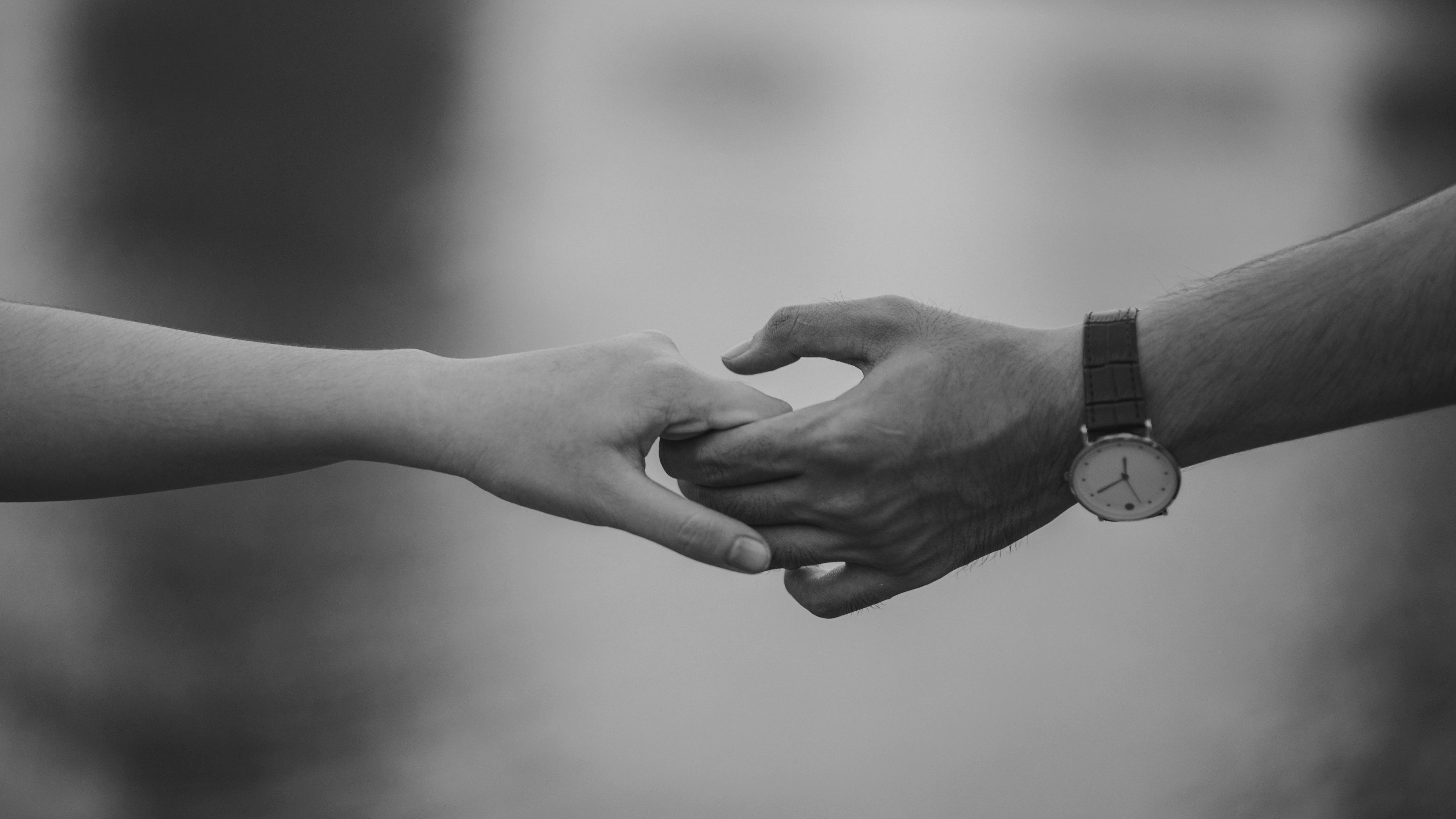 A black and white closeup of a couple holding hands | Source: Pexels