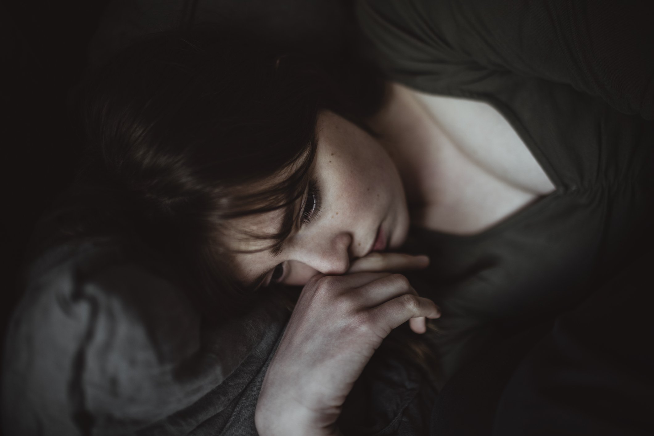 EIne traurige Frau liegt auf dem Bett I Quelle: Getty Images