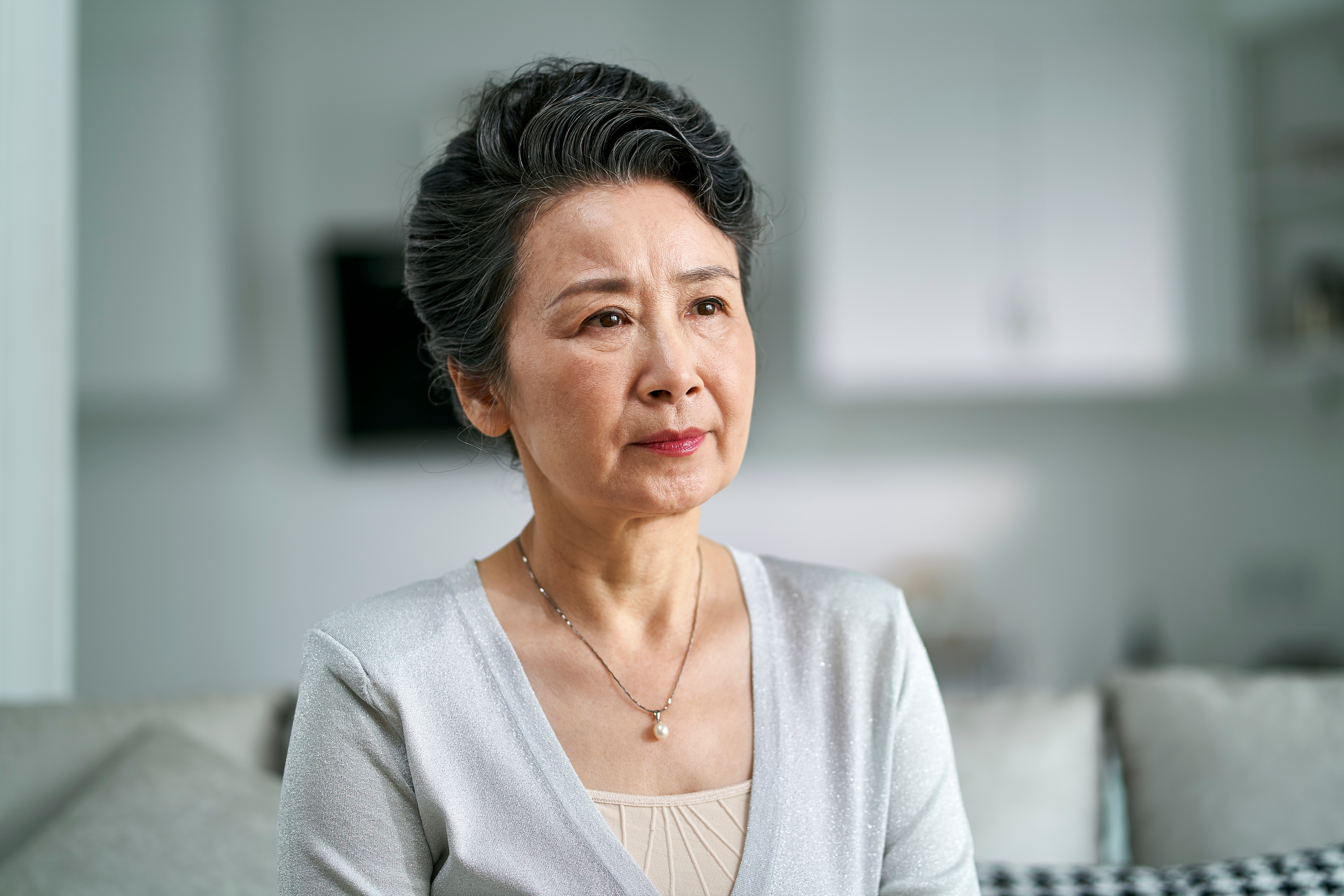 An upset senior woman sitting on a couch | Source: Shutterstock