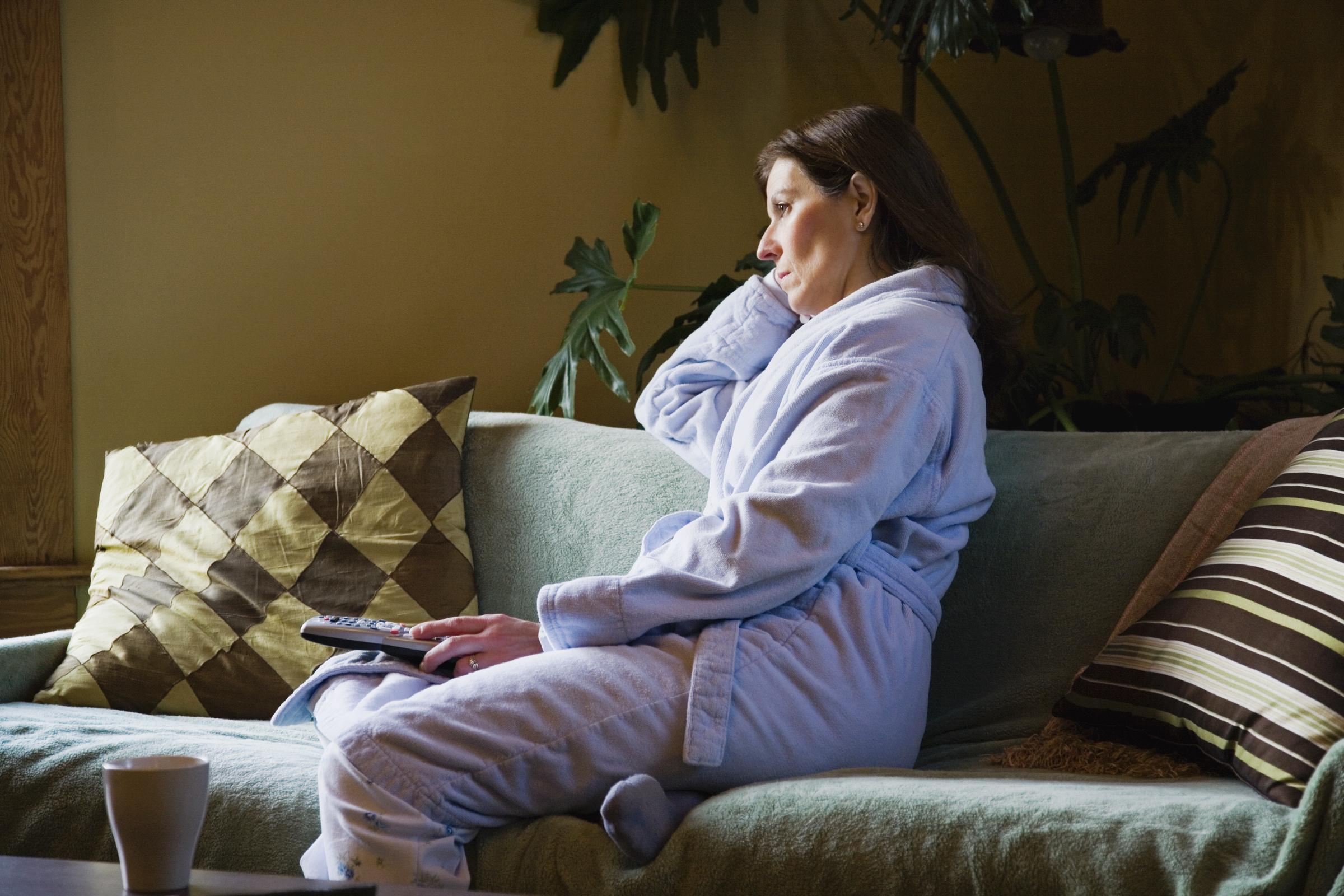 A woman watching TV alone in her pajamas | Source: Getty Images