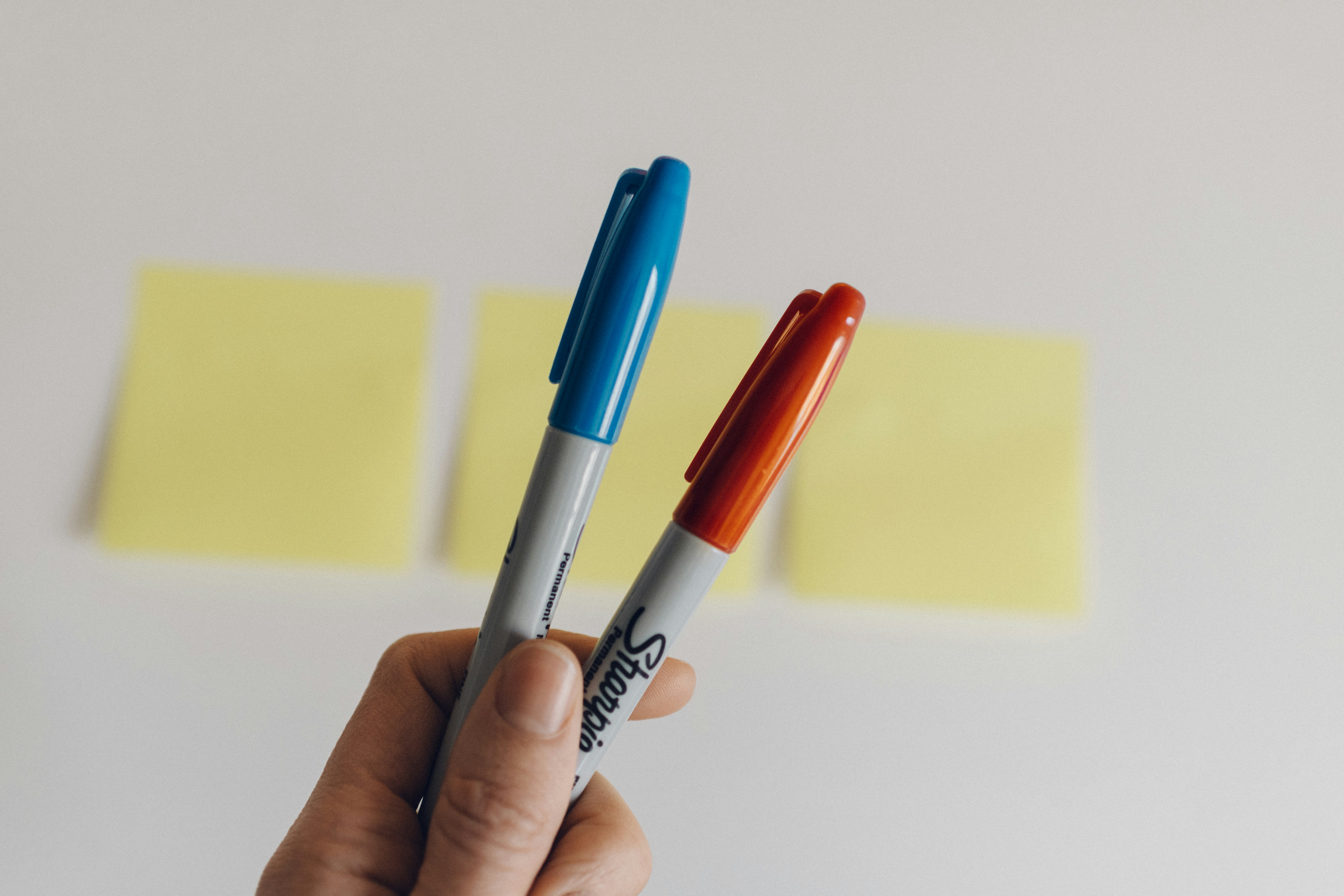 A person holding two Sharpie markers | Source: Unsplash