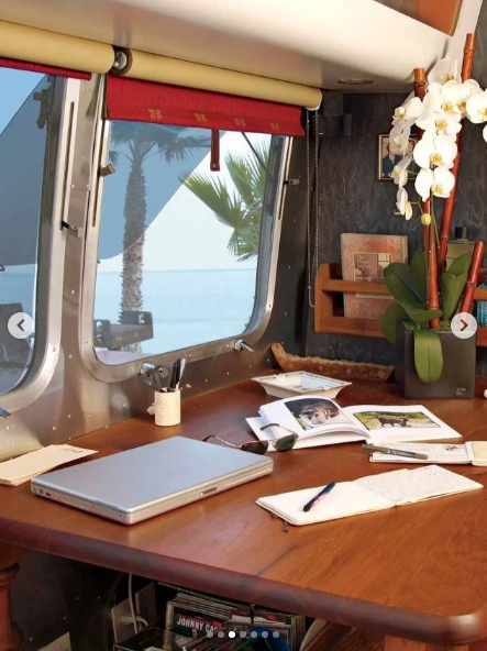 Inside, a large wooden table transformed part of McConaughey's living area into a practical workspace, with his laptop, notebooks, reading material, and other essentials spread across its surface. Wide windows brought the outdoors into the compact trailer and, while parked near the coast, gave the actor an ocean view as he worked from the home that also served as an office for his production company. | Source: Instagram/ivd_ru