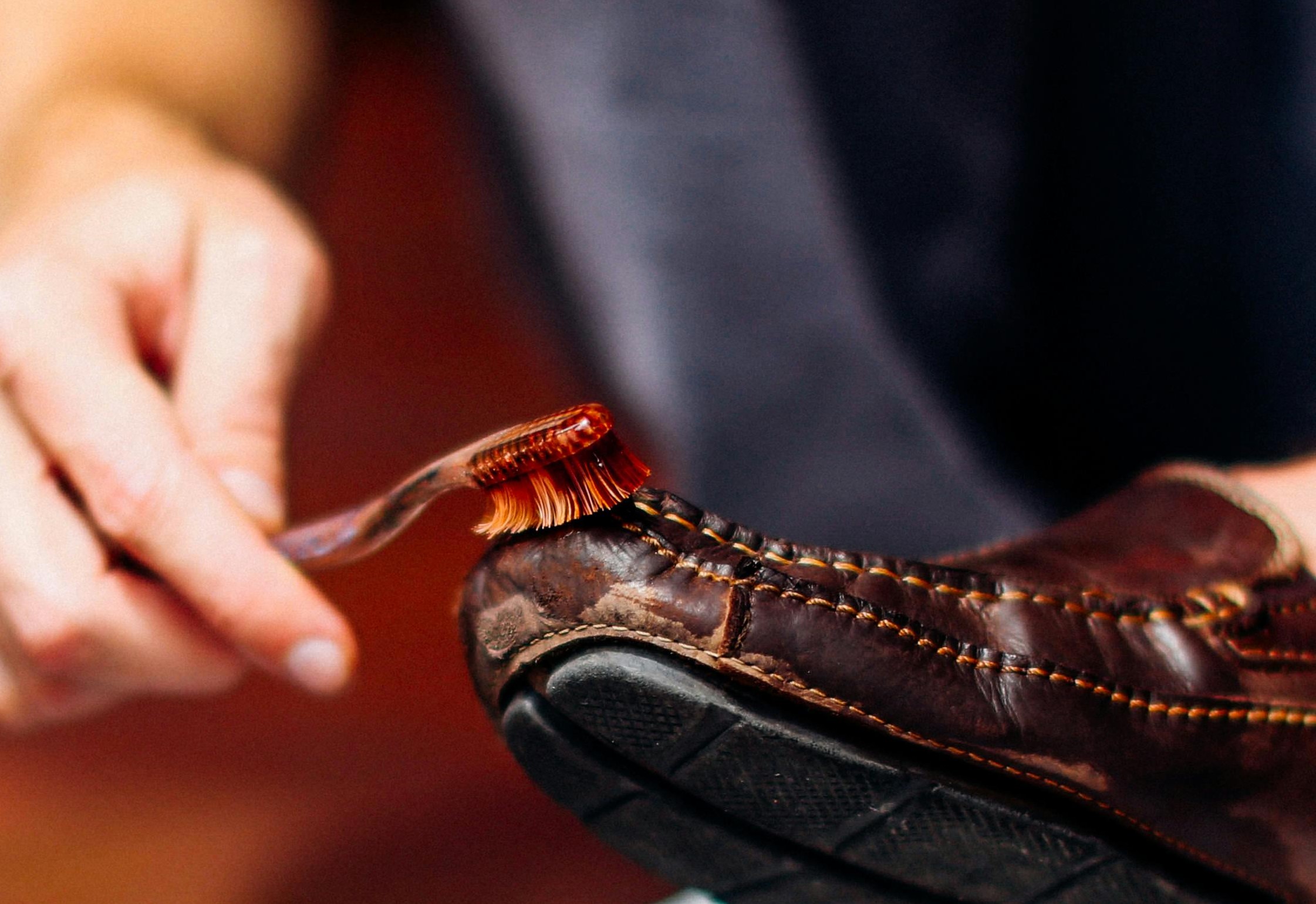 A person brushing a brown shoe | Source: Pexels