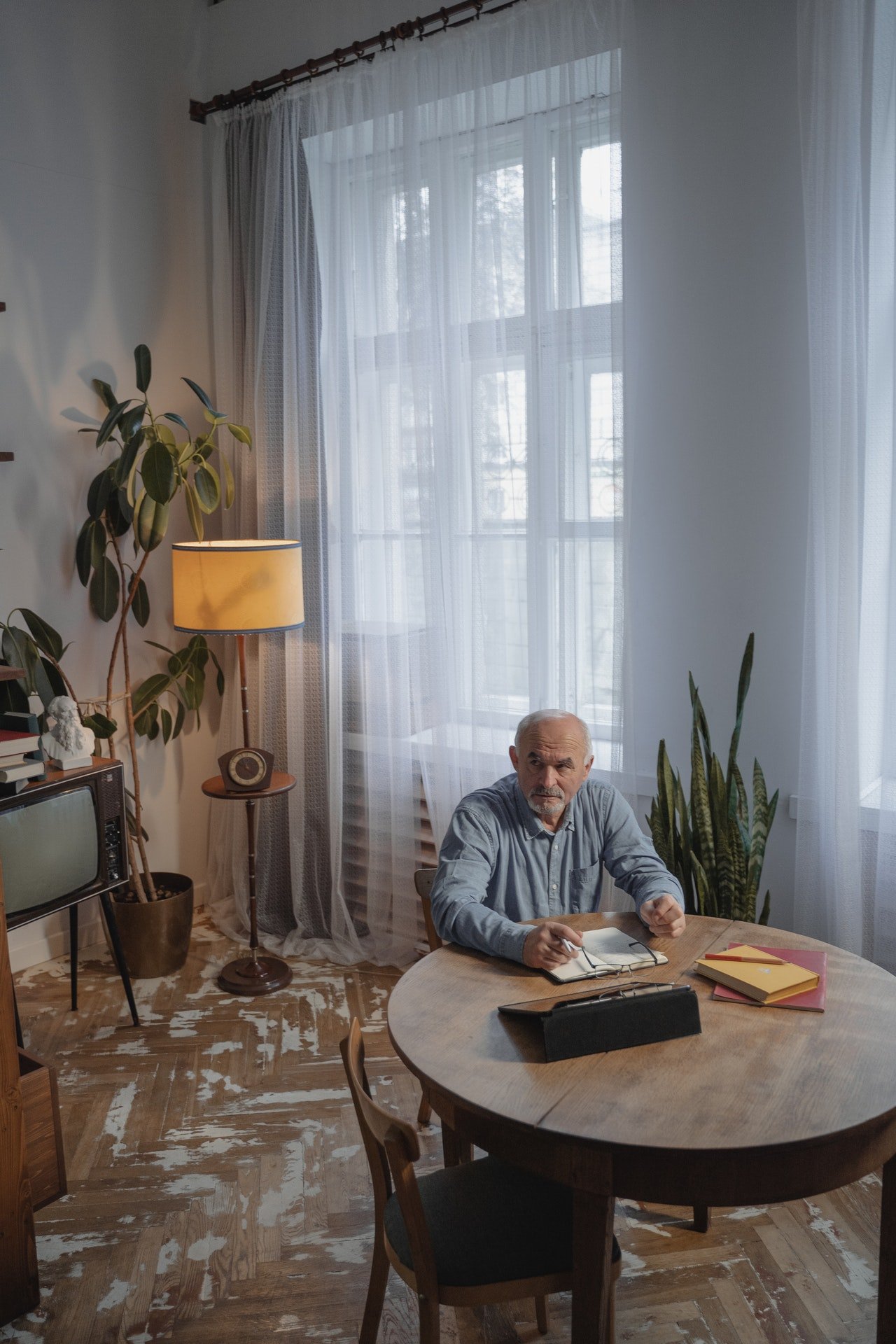 Un hombre mayor sentado frente a una mesa. | Foto: Pexels