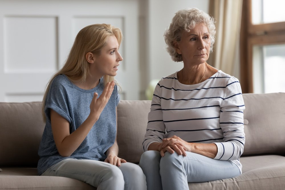 Una madre conversando con su hija sentadas en un sofá. | Foto: Shutterstock
