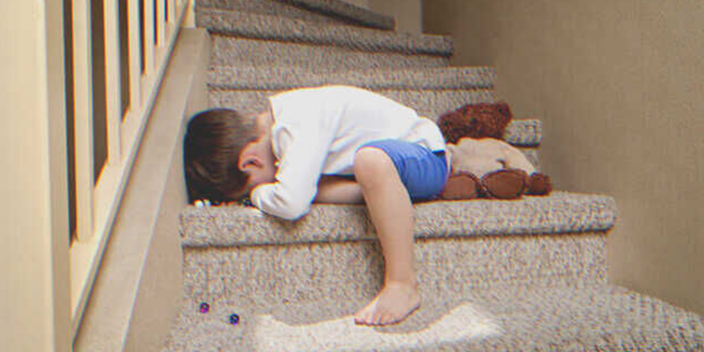A boy crying on the stairs of a house | Source: Shutterstock