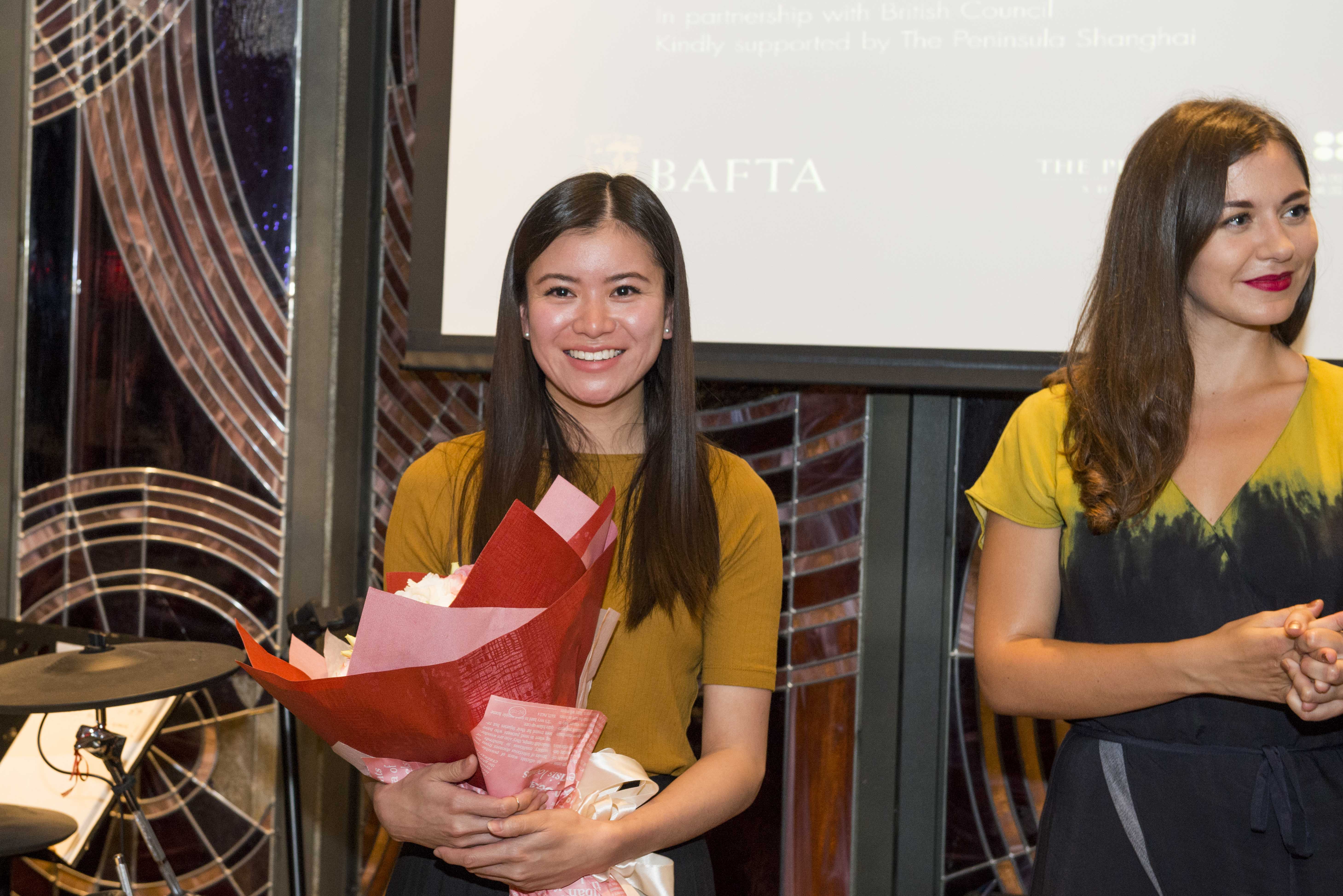 Katie Leung was all smiles alongside Jennifer Majka during the BAFTA and British Council Afternoon Tea on June 18, 2017, in Shanghai — an event that celebrated international collaboration and British creative talent. Holding a bouquet of flowers, Leung radiated warmth and professionalism, embodying her evolution from a breakout teen star to a respected figure representing British acting on the global stage.