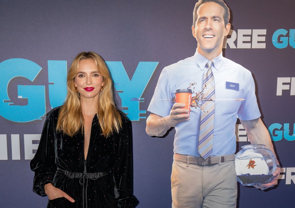 Jodie Comer alongside a cardboard cutout of Ryan Reynolds at Cineworld Leicester Square, central London, for the premiere of Free Guy, August 2021 | Source: Getty Images