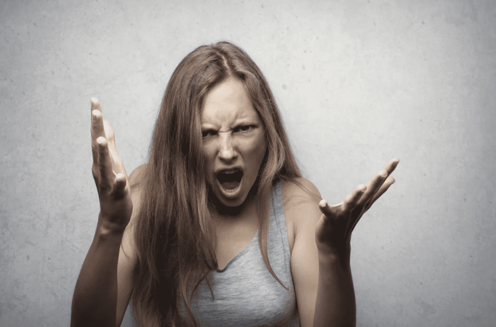 A furious woman in a grey tank top. | Photo: Pexels.
