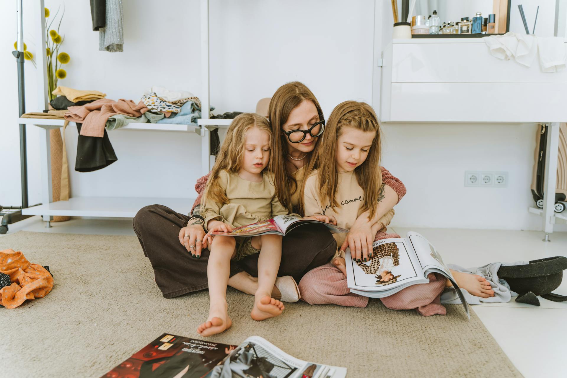 A woman sifting through magazines with her little daughters | Source: Pexels