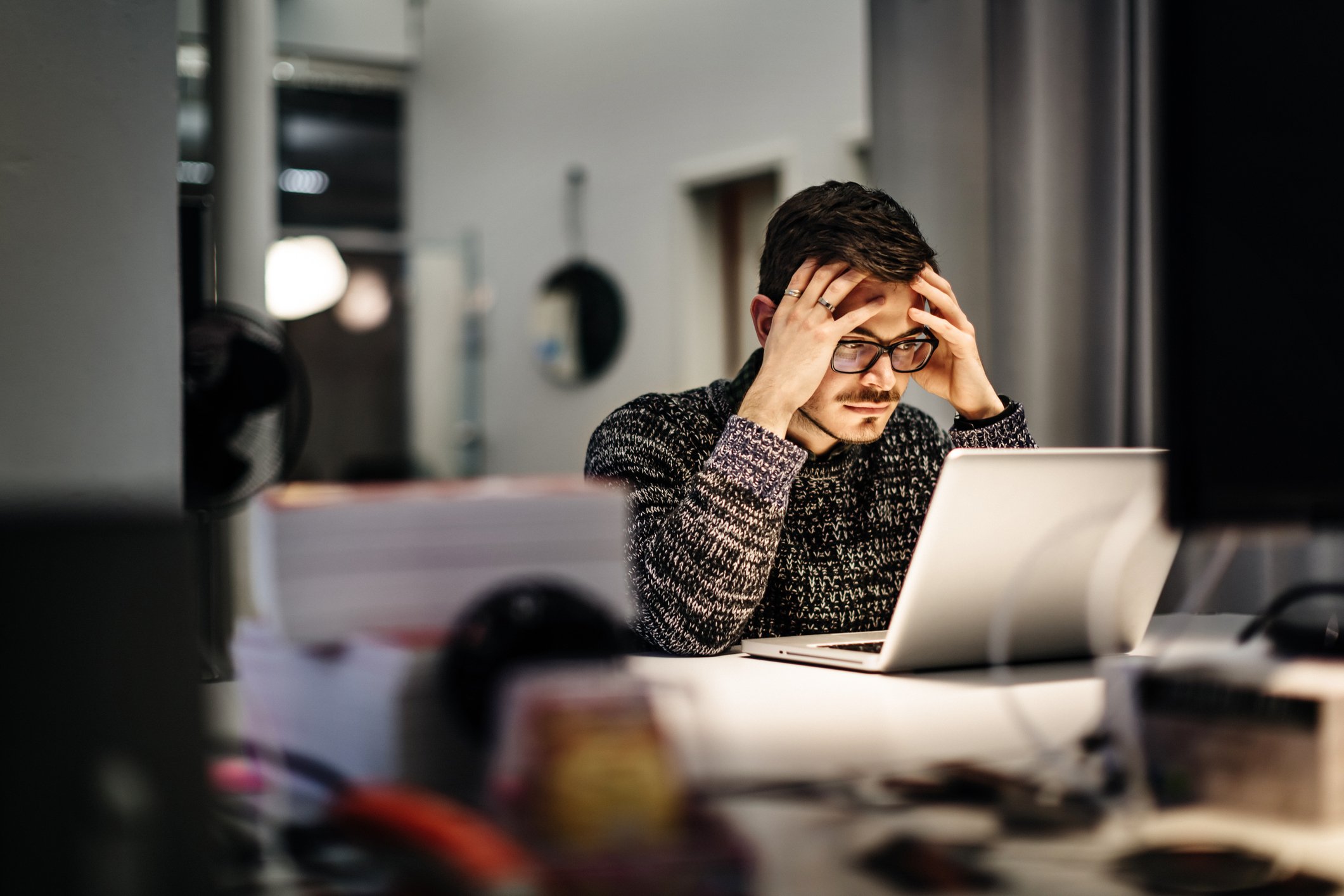 Hombre angustiado frente a una computadora con las manos en su cabeza. | Foto: Shutterstock