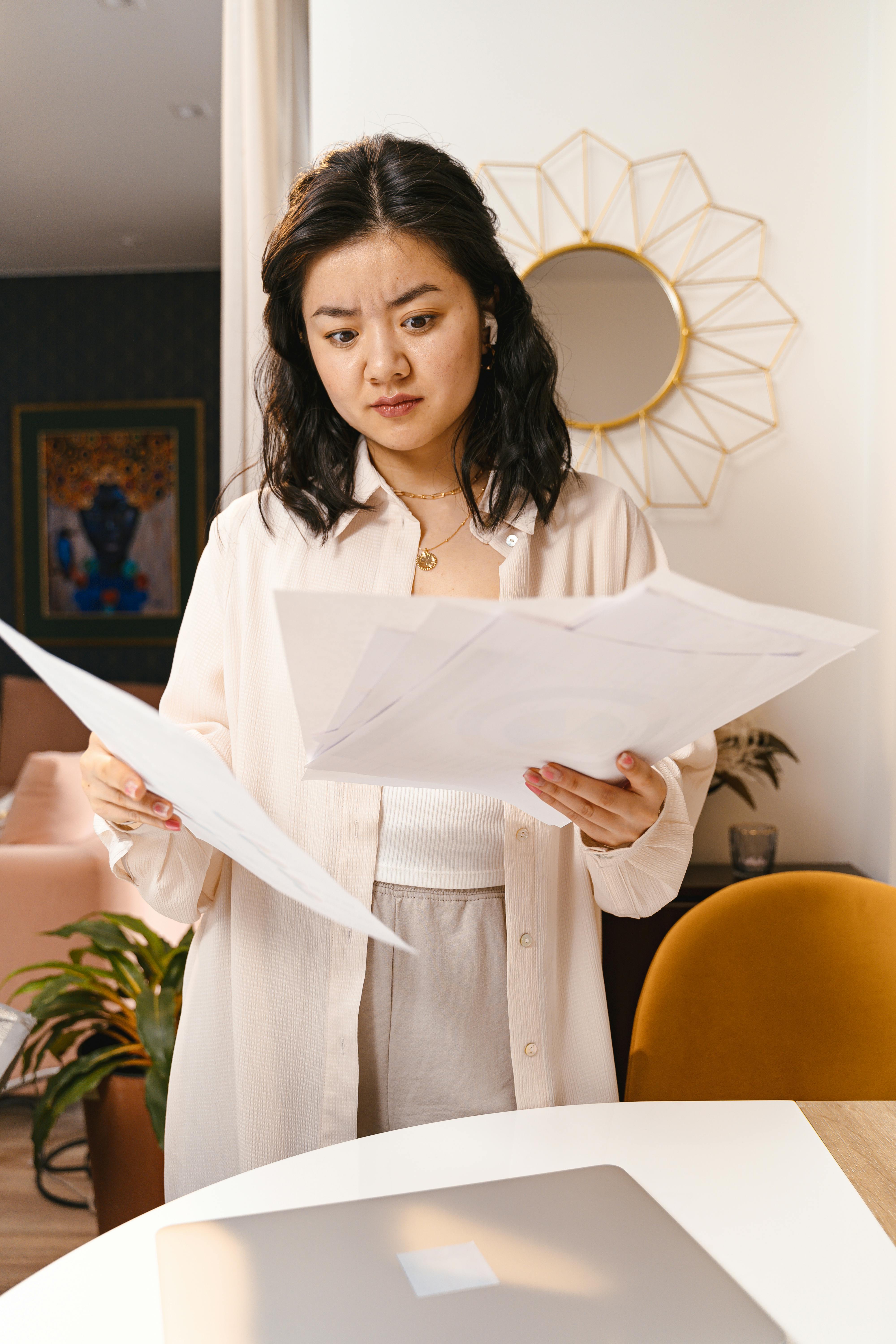 A woman looking at paperwork while contemplating her next move | Source: Pexels