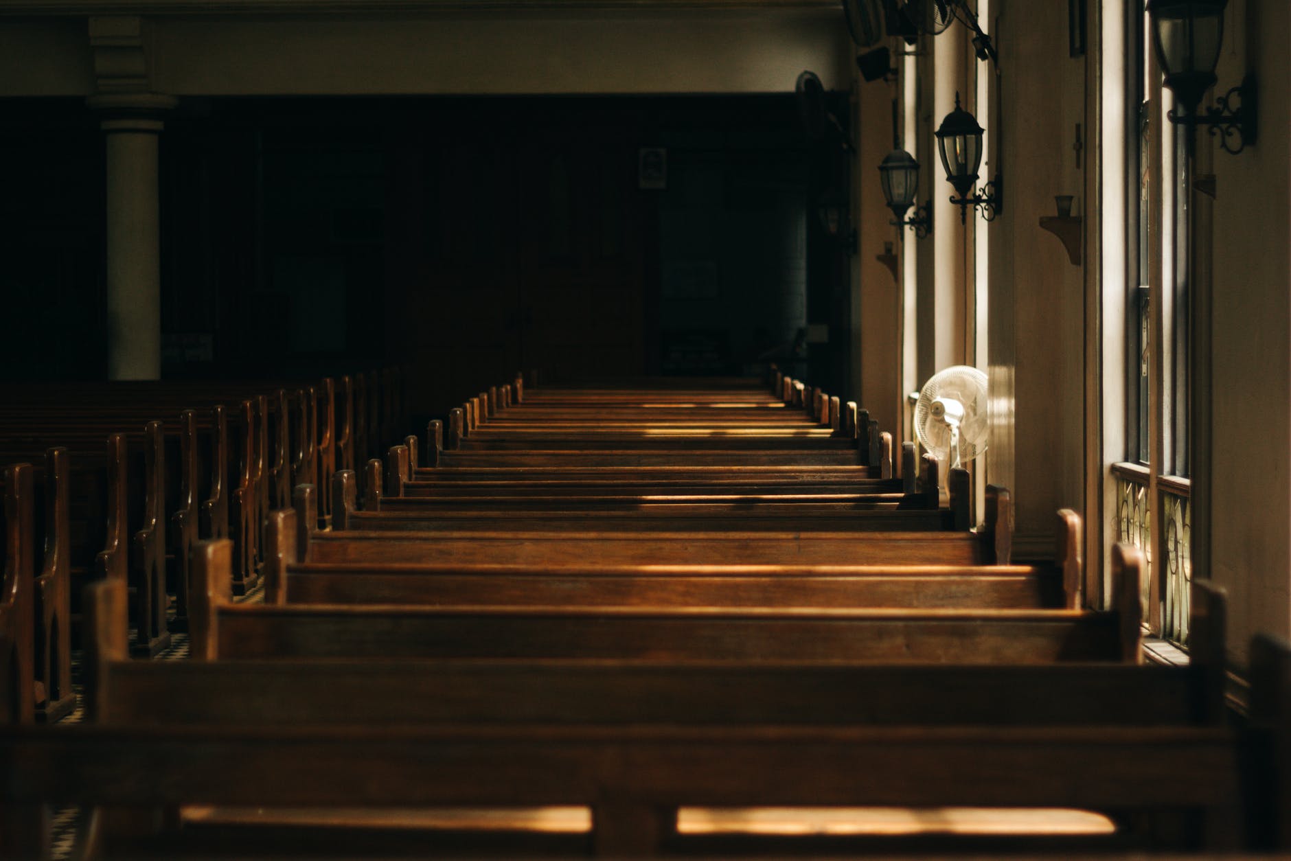 A row of pews inside a dark church | Source: Pexels
