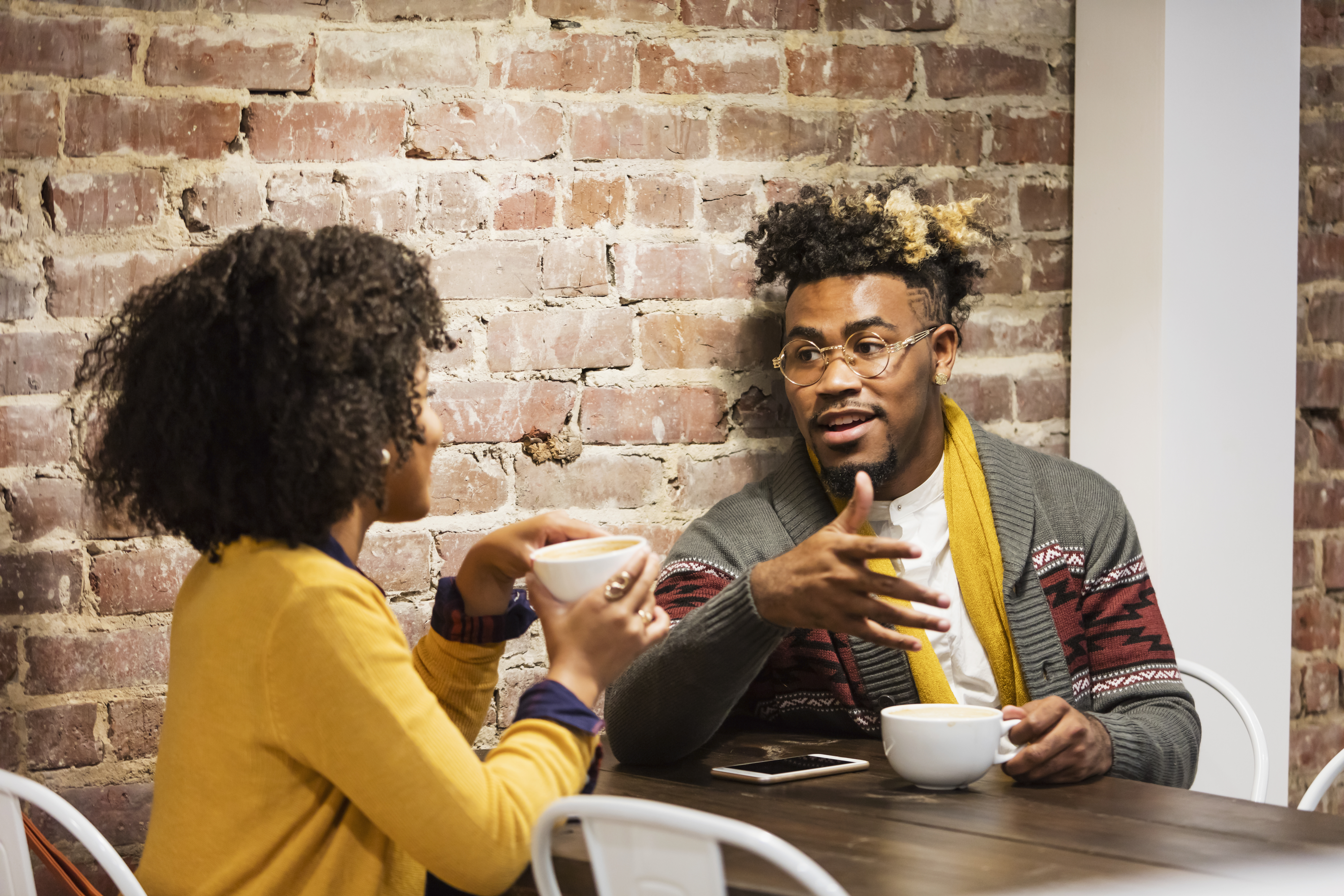 Young mixed race couple talking in coffee shop | Source: Getty Images