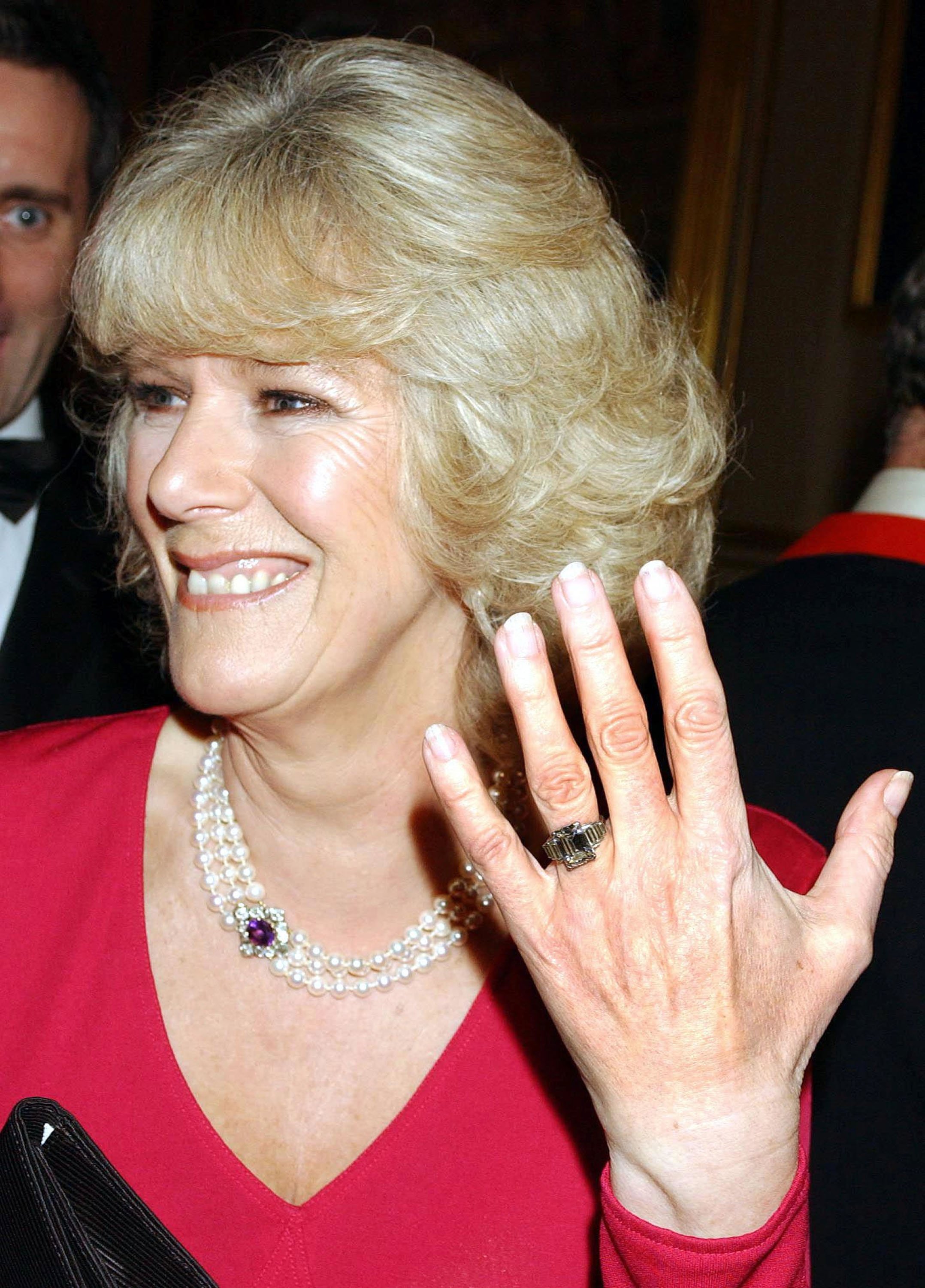 Camilla Parker Bowles zeigt ihren Verlobungsring, als sie nach der Bekanntgabe ihrer Verlobung am 10. Februar 2005 zu einer Party auf Schloss Windsor eintrifft. | Quelle: Getty Images