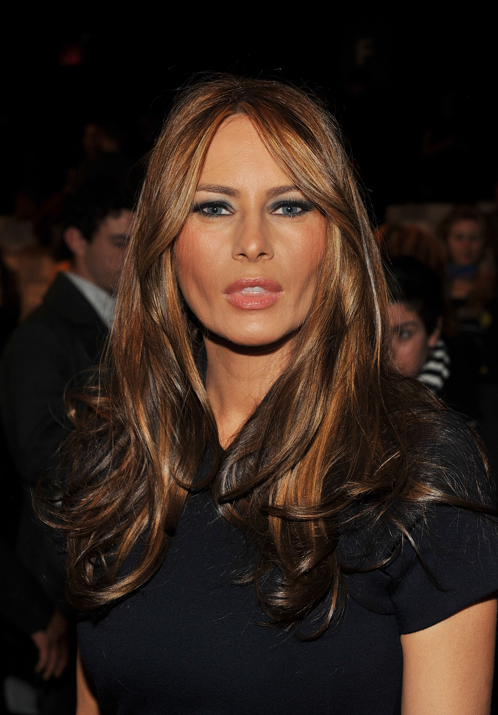 Melania Trump arrives with layered highlighted hair, defined cheekbones, and dramatic eye makeup. The close-up captures her evolving public image.