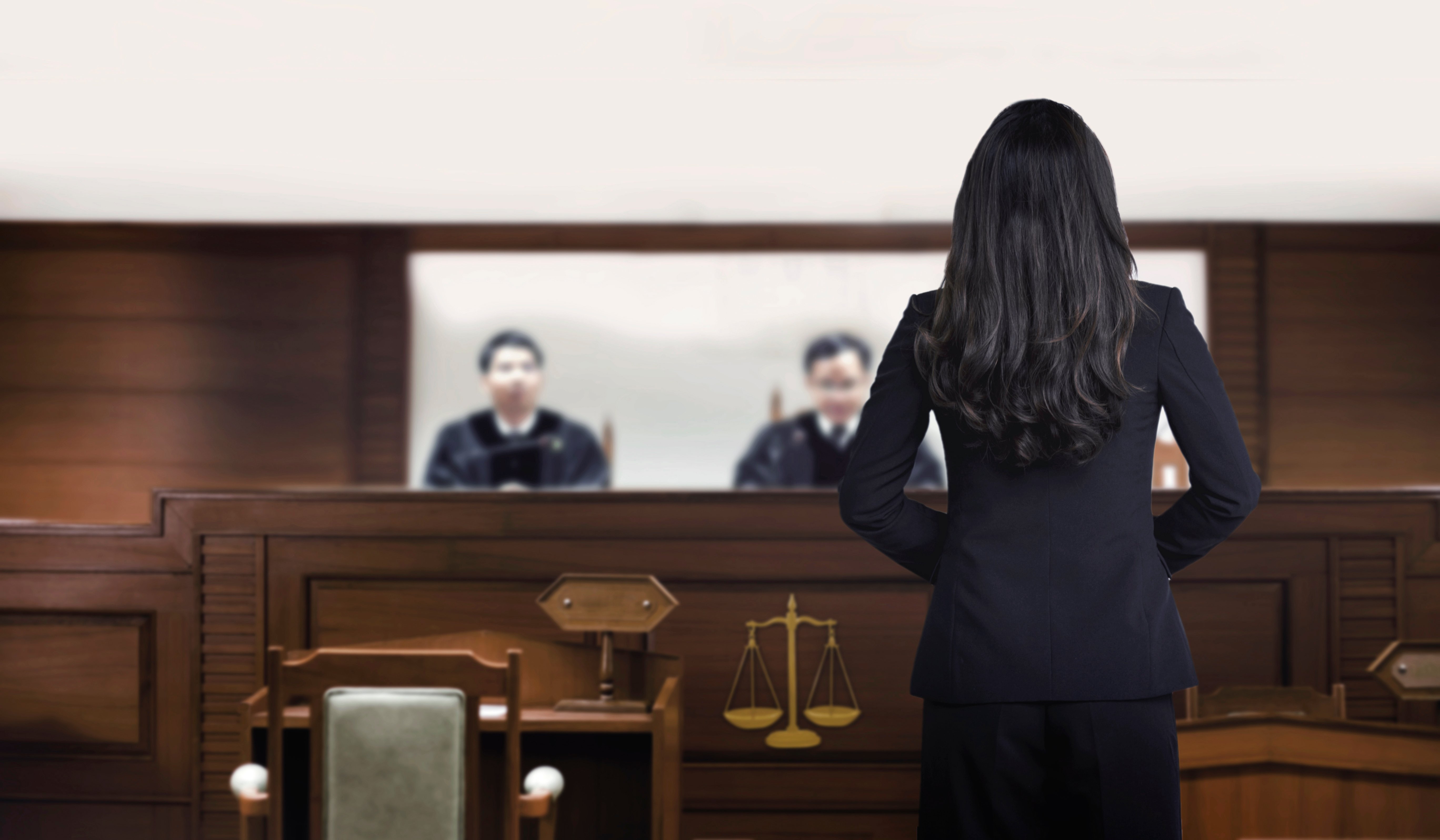 A female attorney in a courtroom talking to magistrate in court box | Photo: Shutterstock