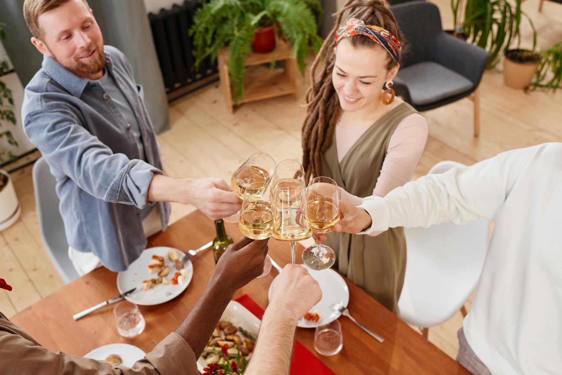 People clinking glasses at a dinner party | Source: Pexels