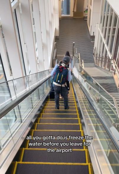 People going down an escalator at an airport, as seen in a video September 12, 2023 | Source: TikTok/@gracietravels