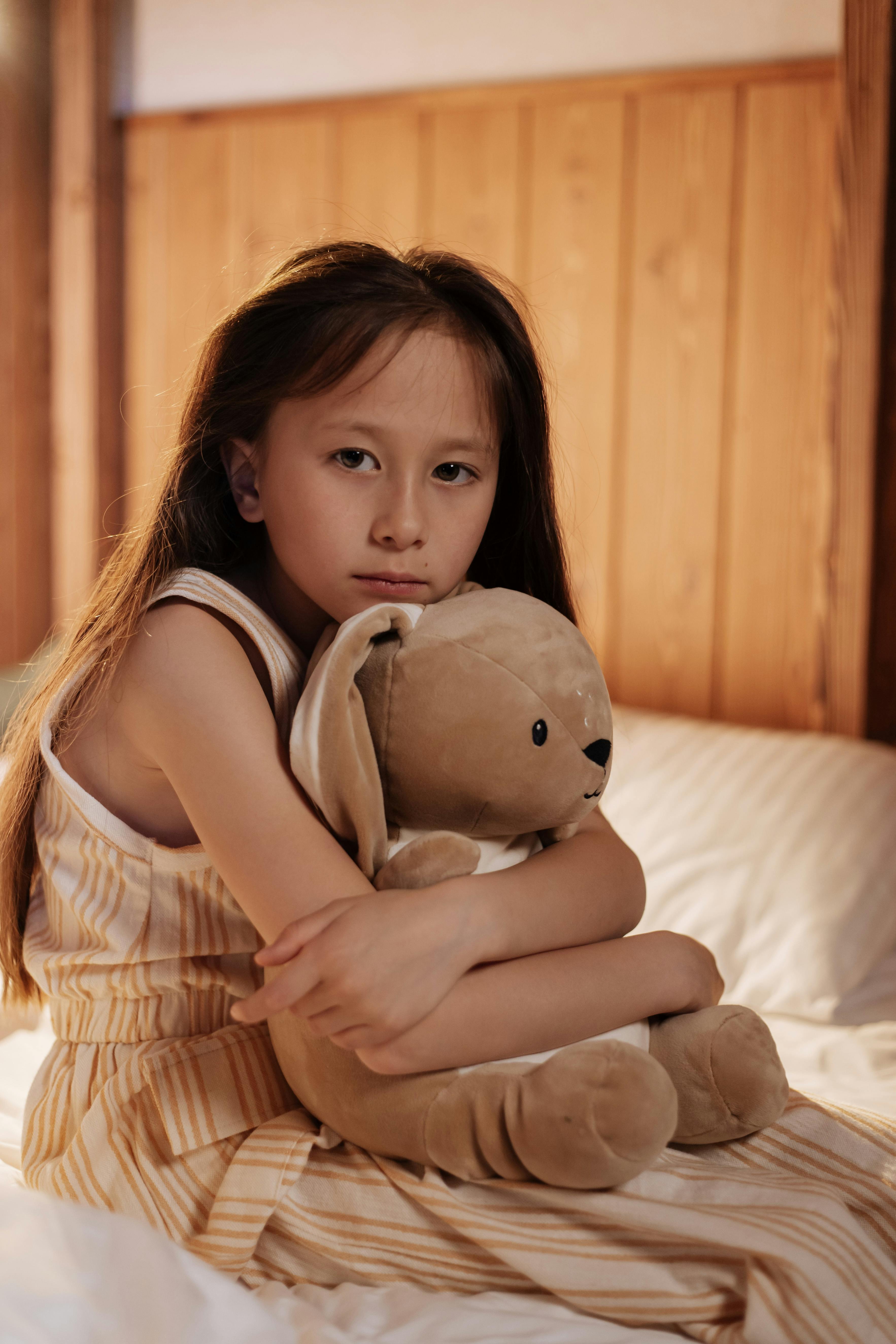 A sad girl hugging a stuffed animal | Source: Pexels