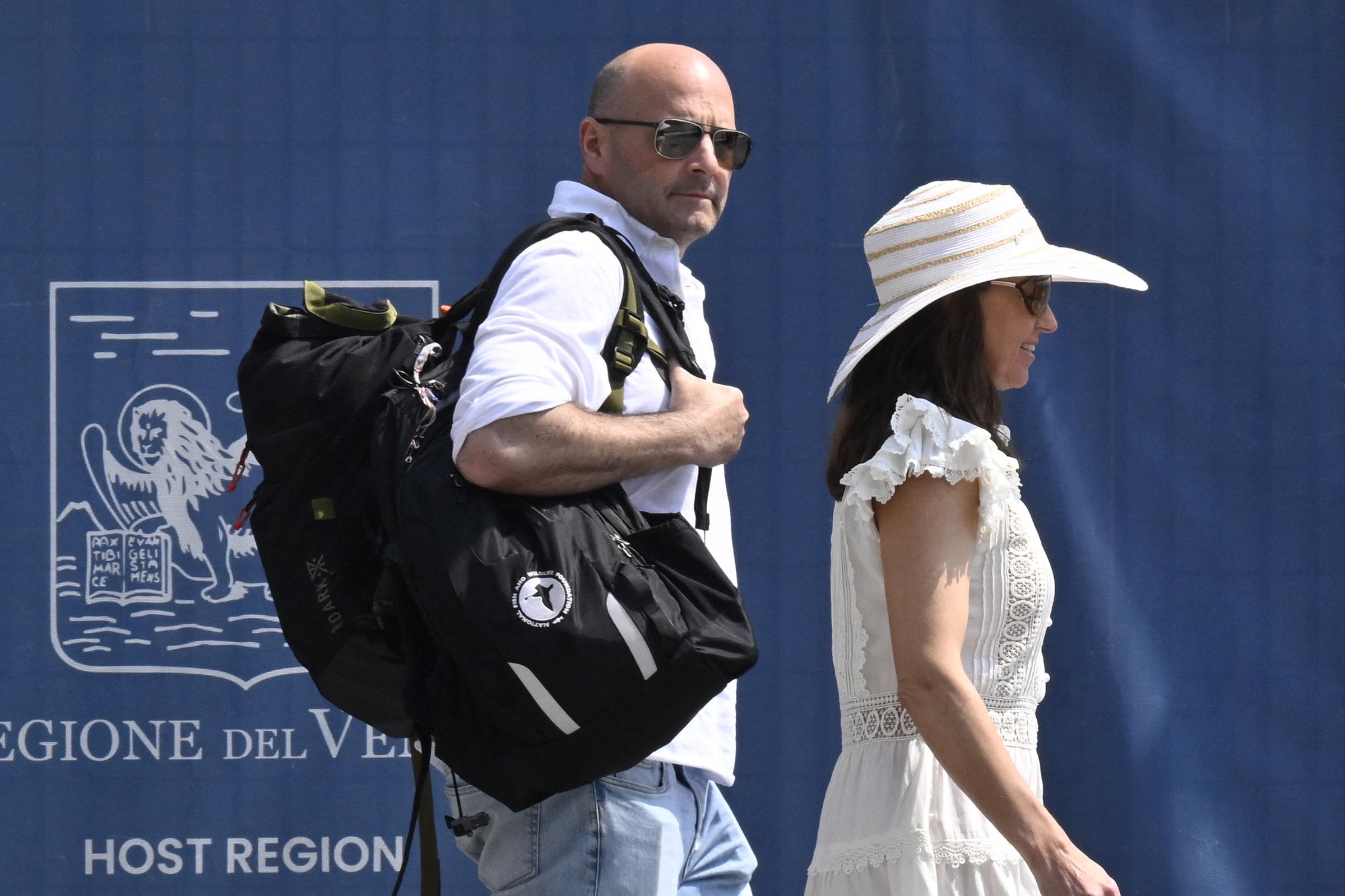 US designer Spencer Antle (L) prepares to board a taxi boat as he arrives at Venice airport on June 25, 2025. He is dressed in white shirt and jeans with a backpack hanging on his shoulder and sunglasses on his face