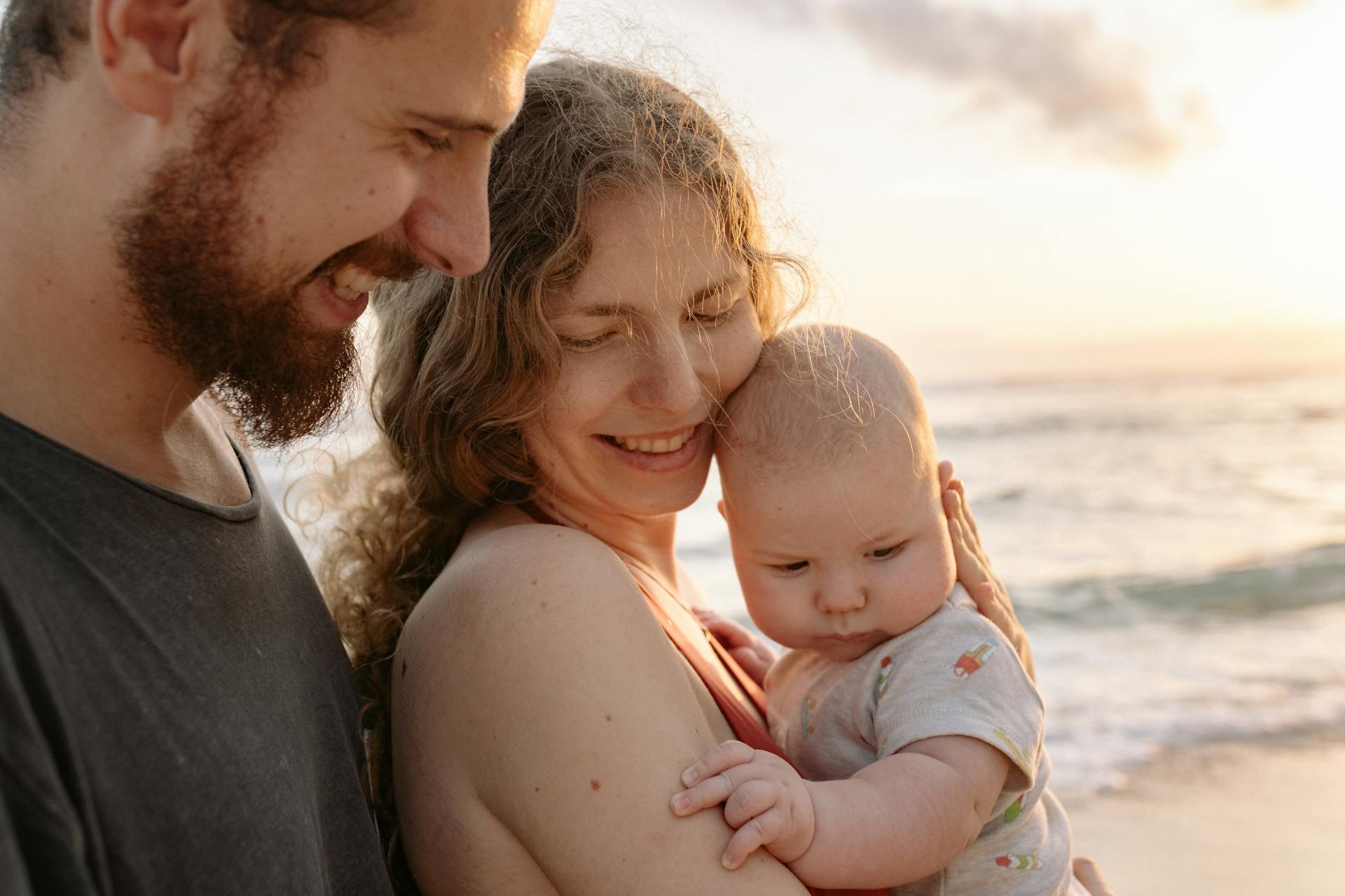 Happy parents holding a baby | Source: Pexels