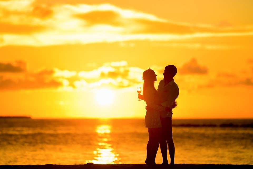 Couple enjoying the sunset at the beach. | Photo: Pixabay