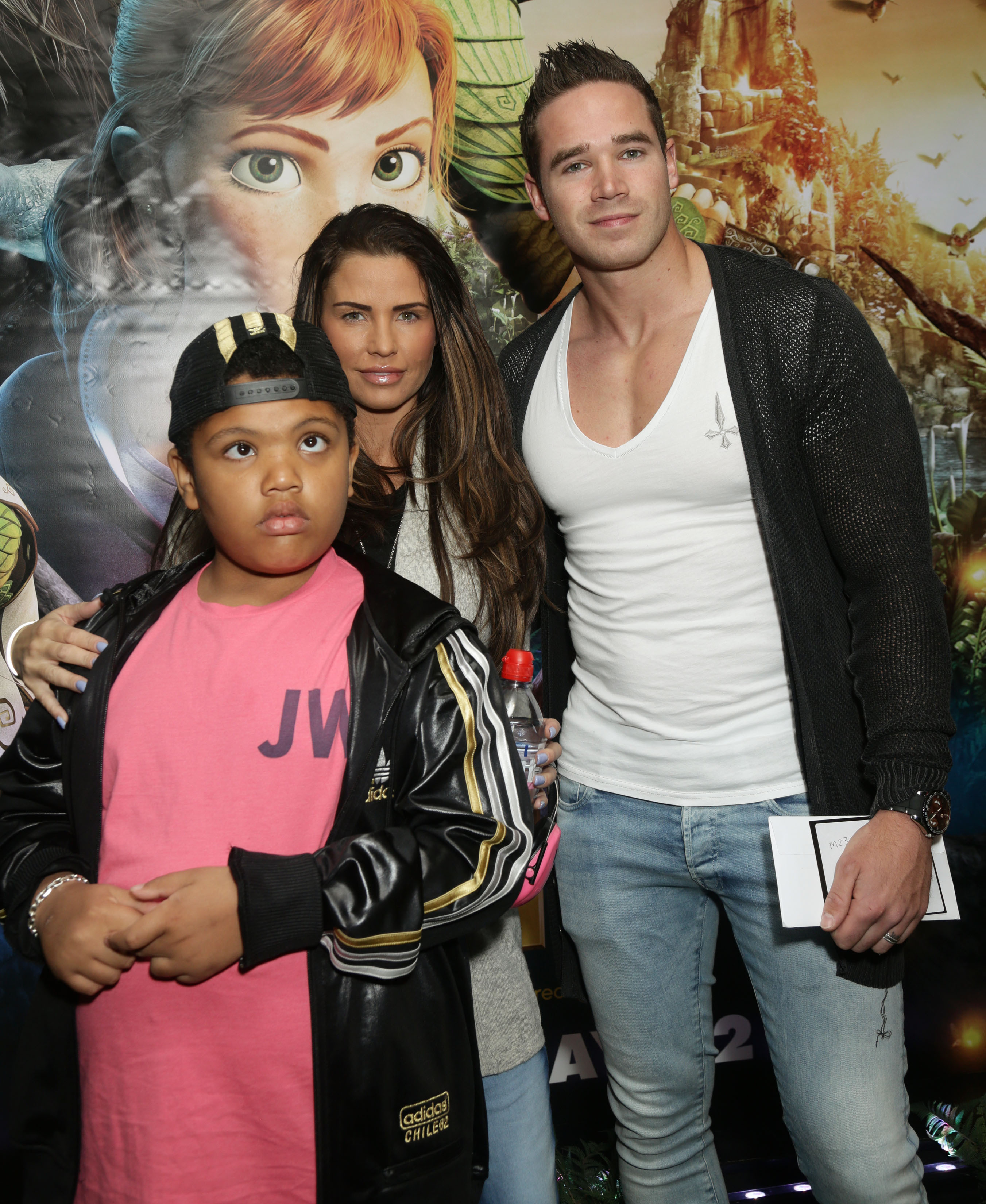 Katie Price attends the gala film screening of "Epic" in London on December 5, 2013, with her son, Harvey Price, and then-husband Kieran Hayler. With Harvey front and centre in a bright pink T-shirt and baseball cap, the trio posed against the animated backdrop, capturing a moment of blended family life during Katie's marriage to Kieran.