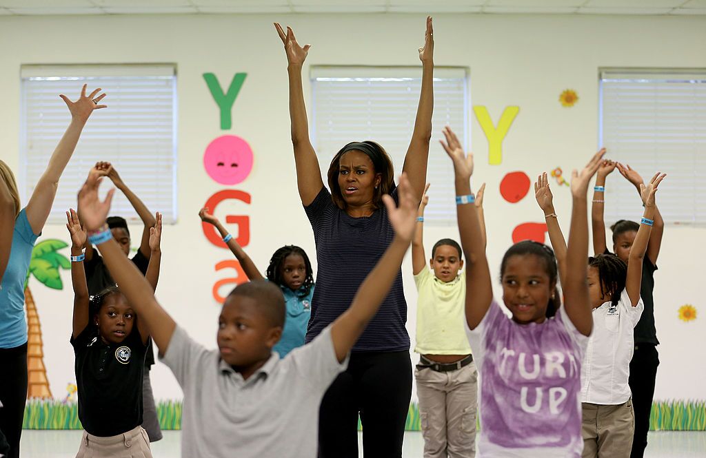 Michelle Obama participates in a yoga class during a visit to the Gwen Cherry Park NFL/YET Center on February 25, 2014 in Miami, Florida. | Photo: Getty Images
