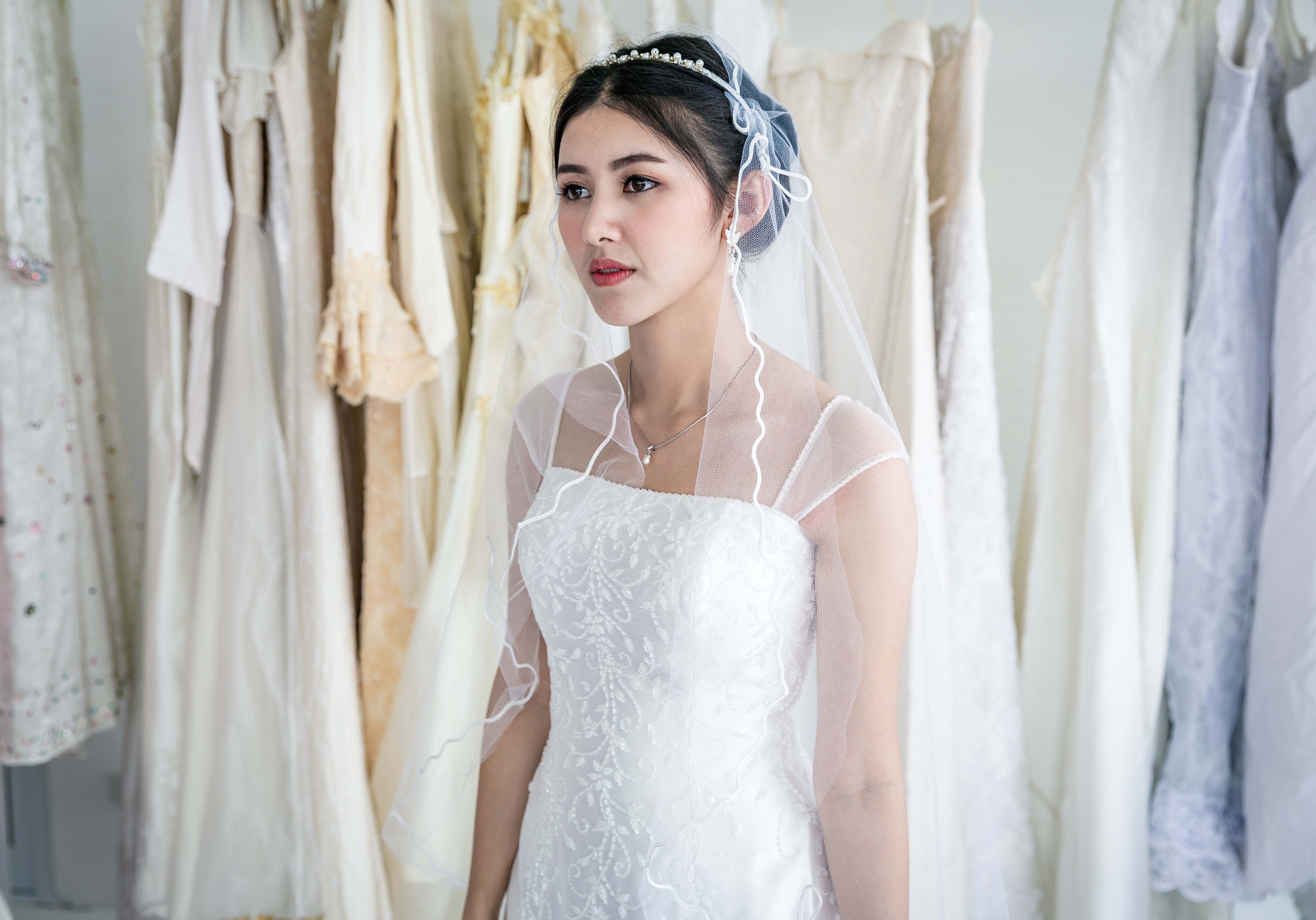Beautiful bride woman standing with wedding dress in room | Source: Getty Images