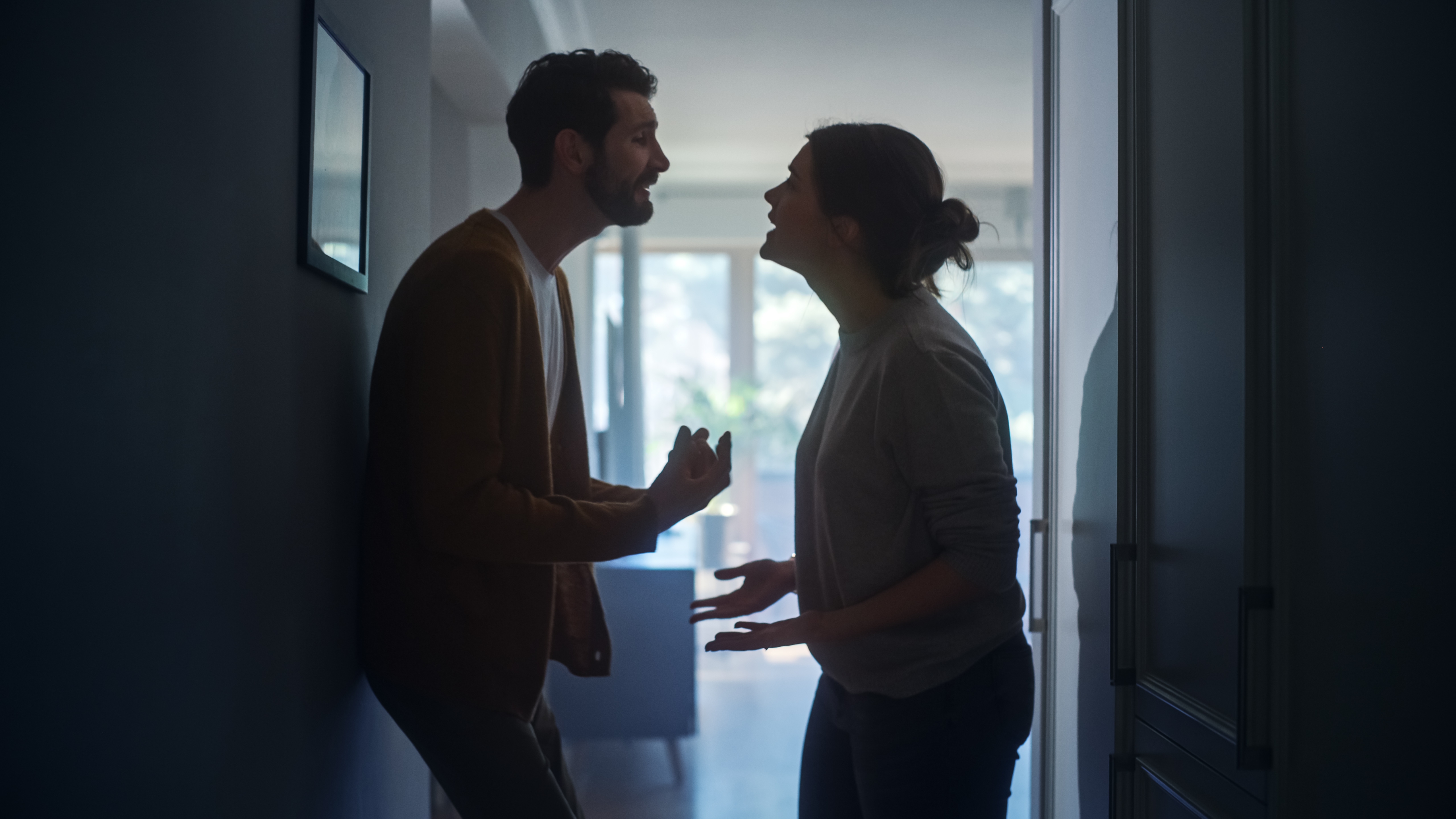 A couple arguing in a hallway | Source: Shutterstock