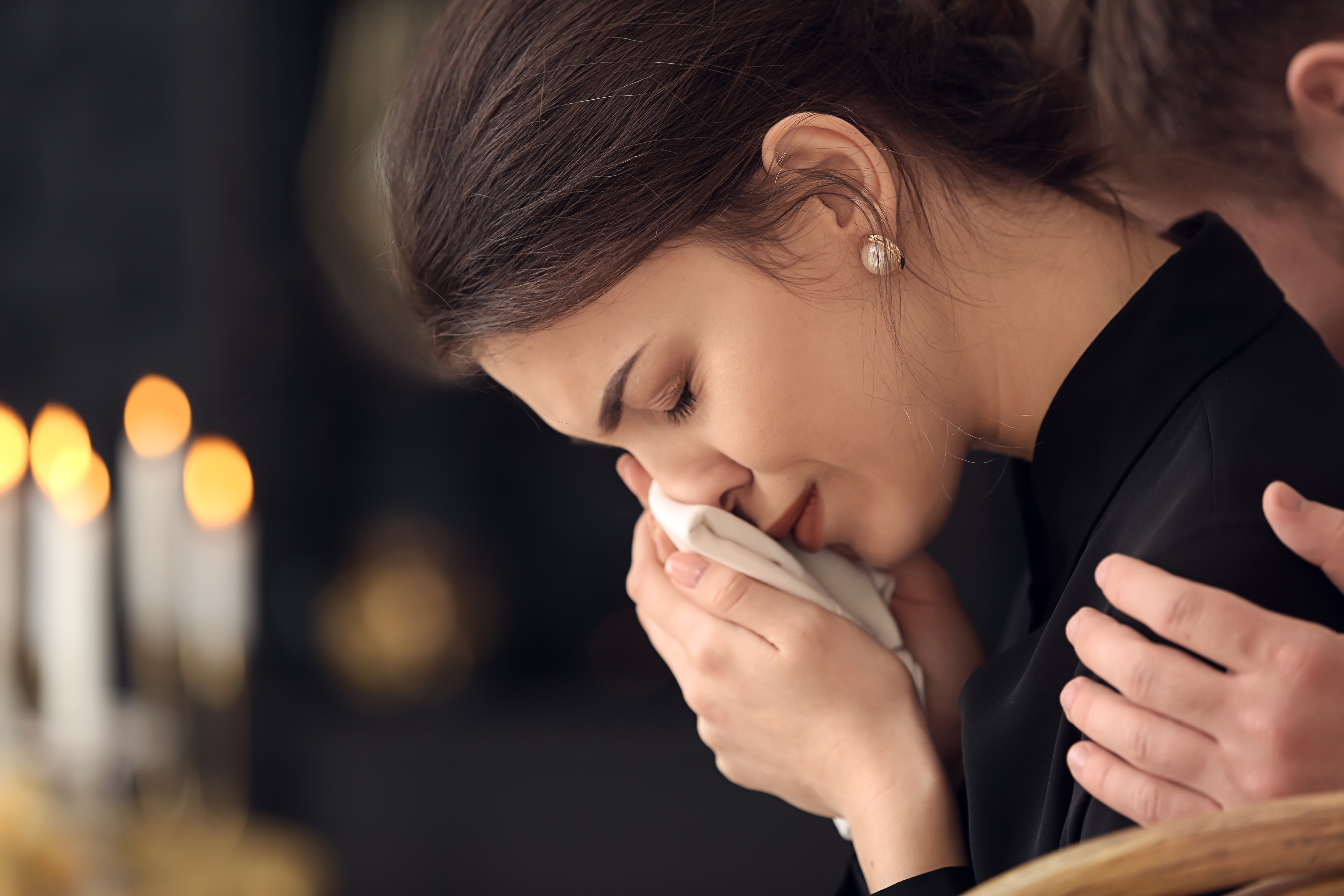 A young woman crying at a funeral | Source: Shutterstock