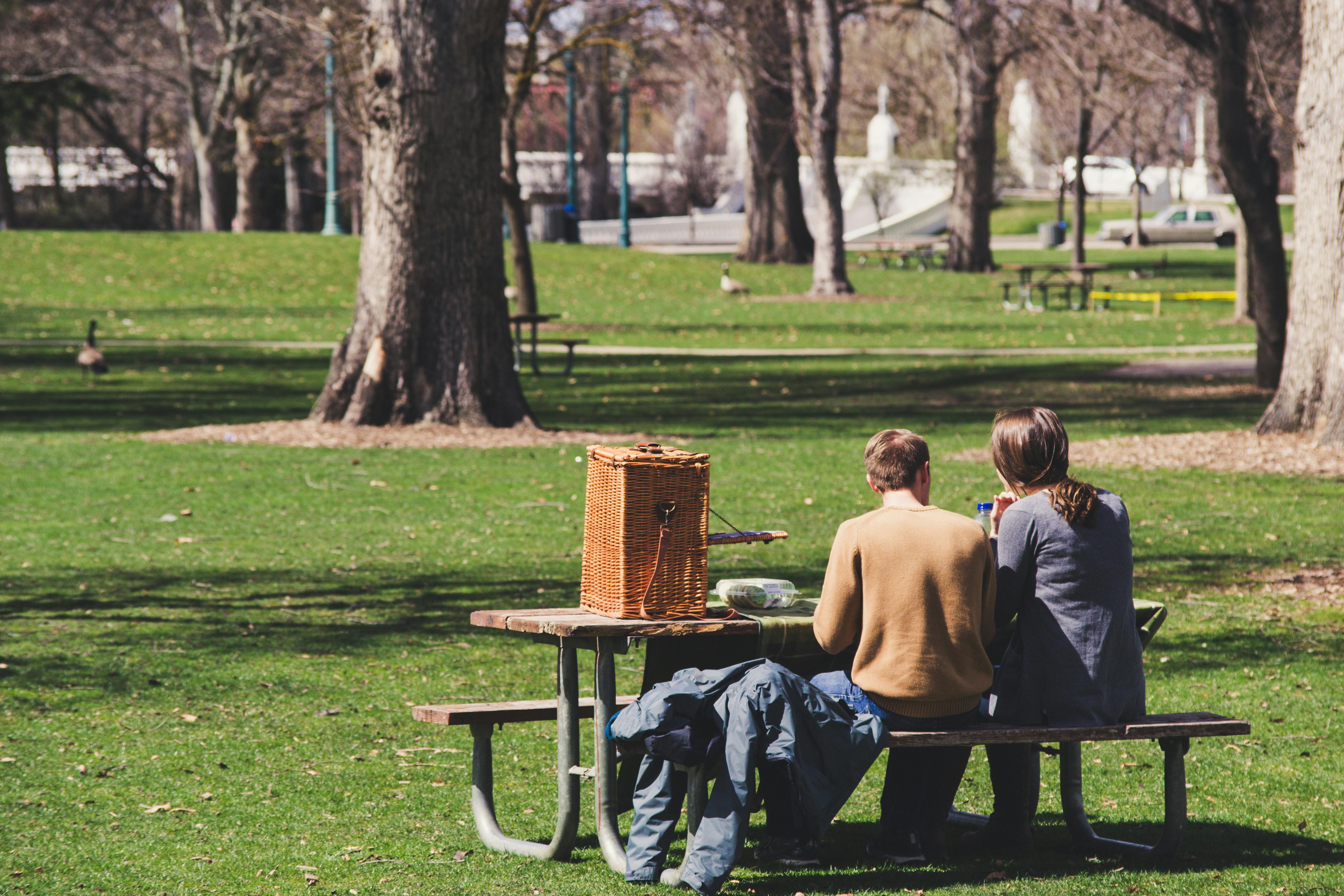 A man and a woman sitting at a picnic table | Source: Pexels