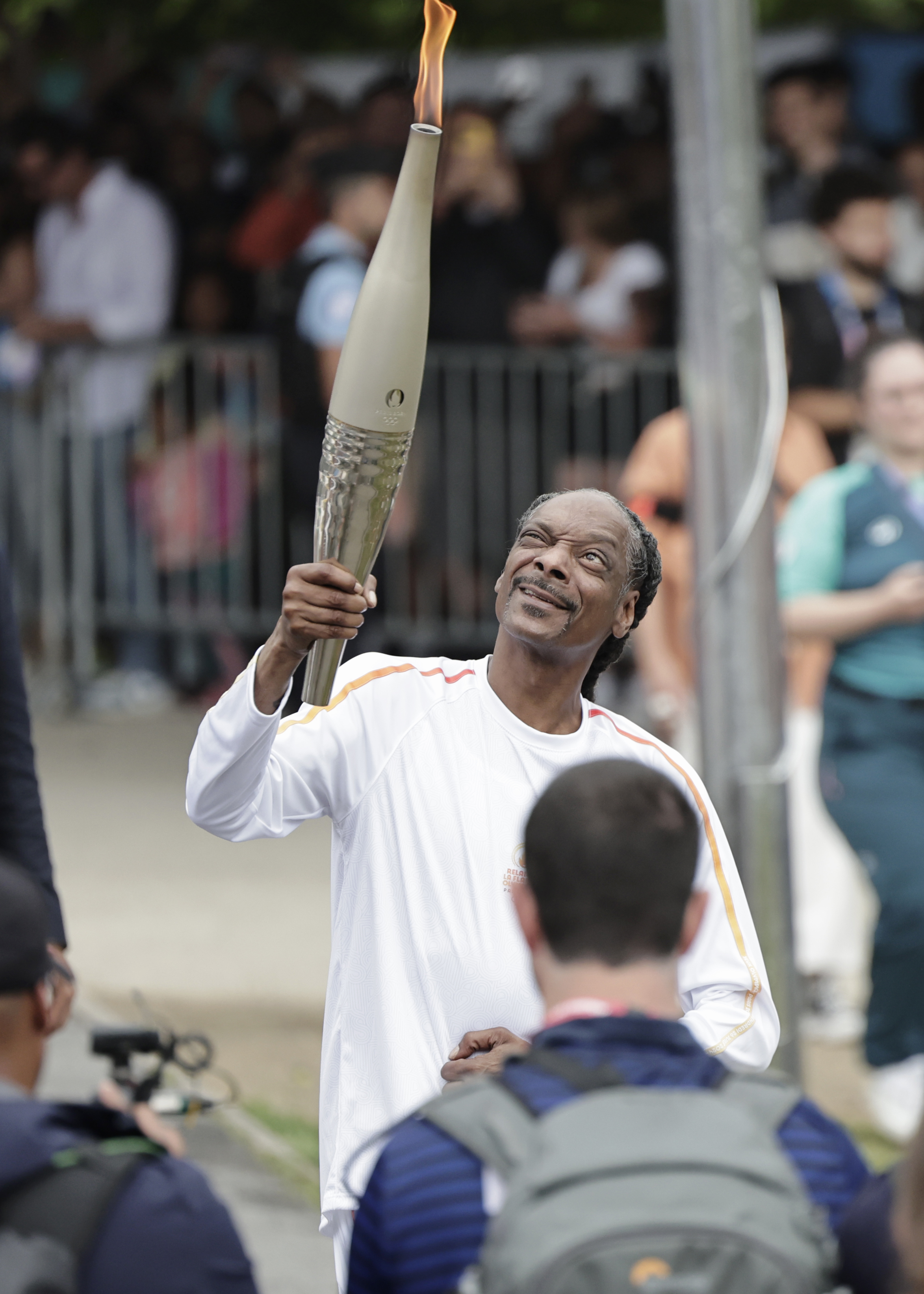 Snoop Dogg holds the torch as part of the 2024 Paris Olympic Games Torch Relay on July 26, 2024, in Saint-Denis in Paris, France. | Source: Getty Images