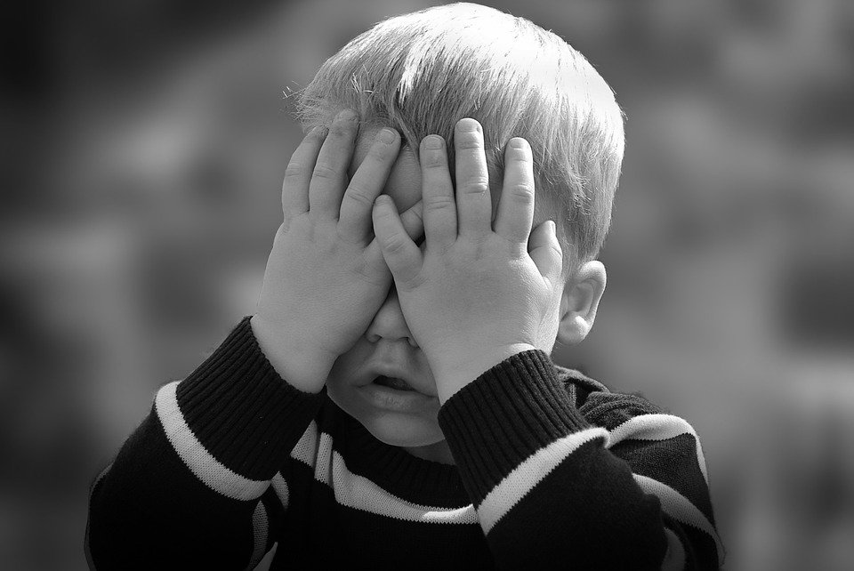 Un petit garçon qui se cache le visage. | Photo : Pixabay
