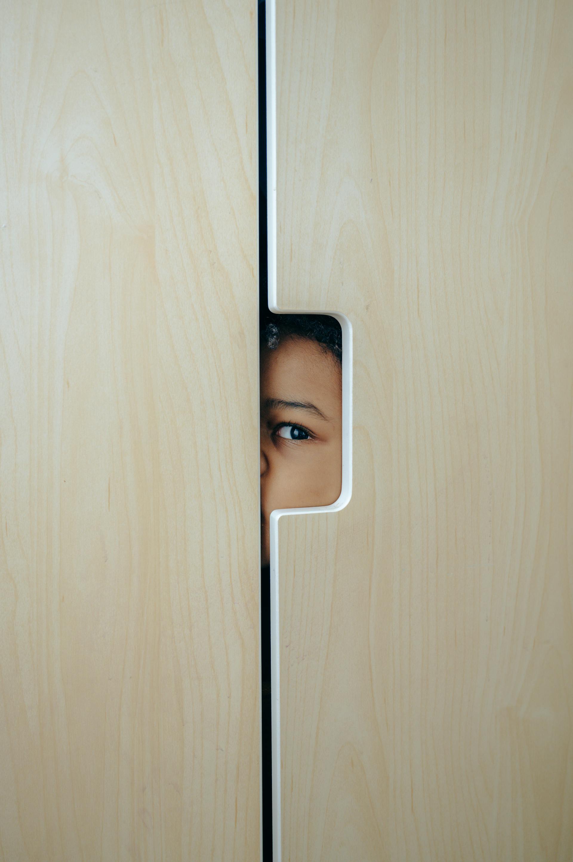 A little boy hiding in the wardrobe | Source: Pexels