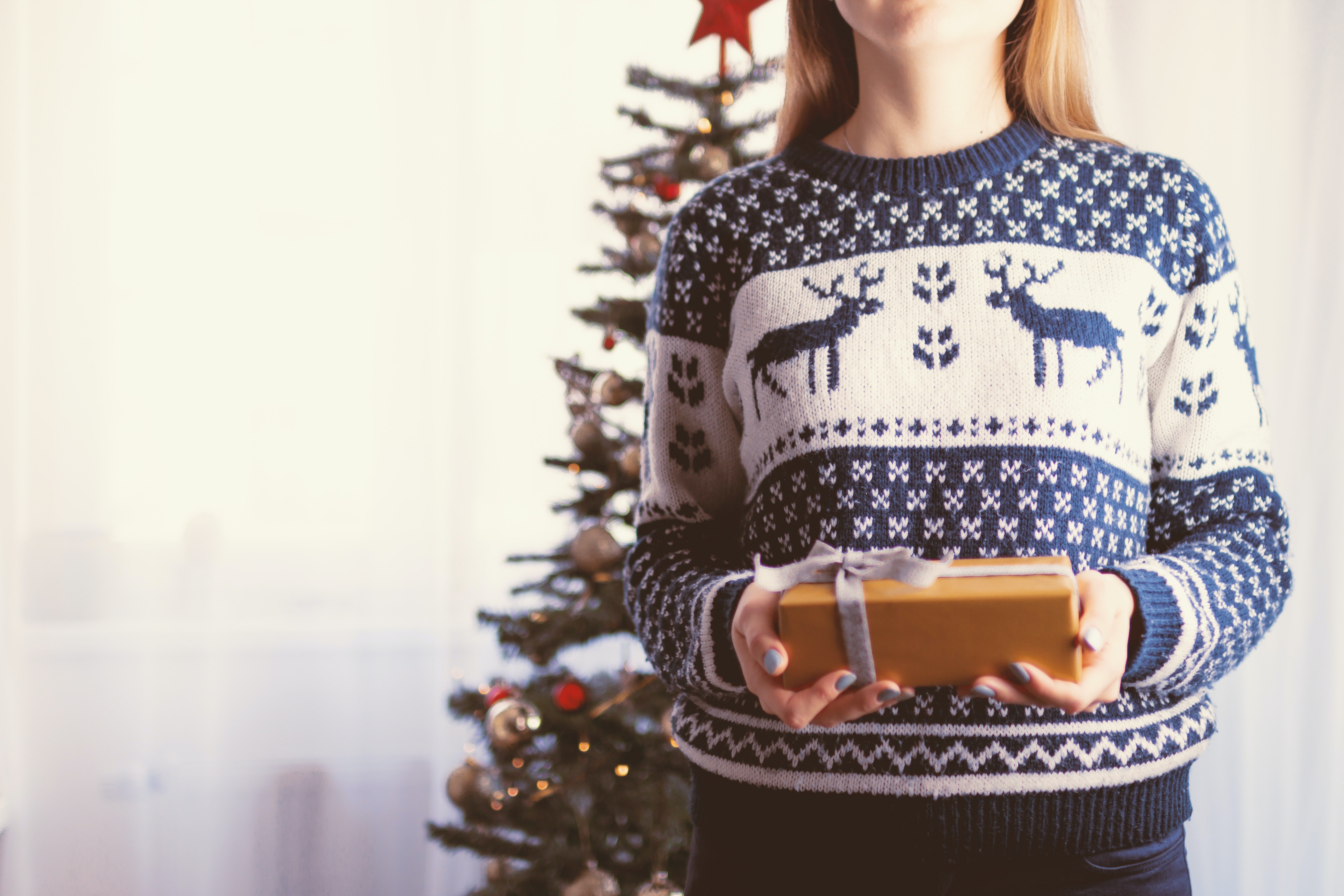 Young girls holds a Christmas present in her hands | Photo: Pexels/JESHOOTS.com