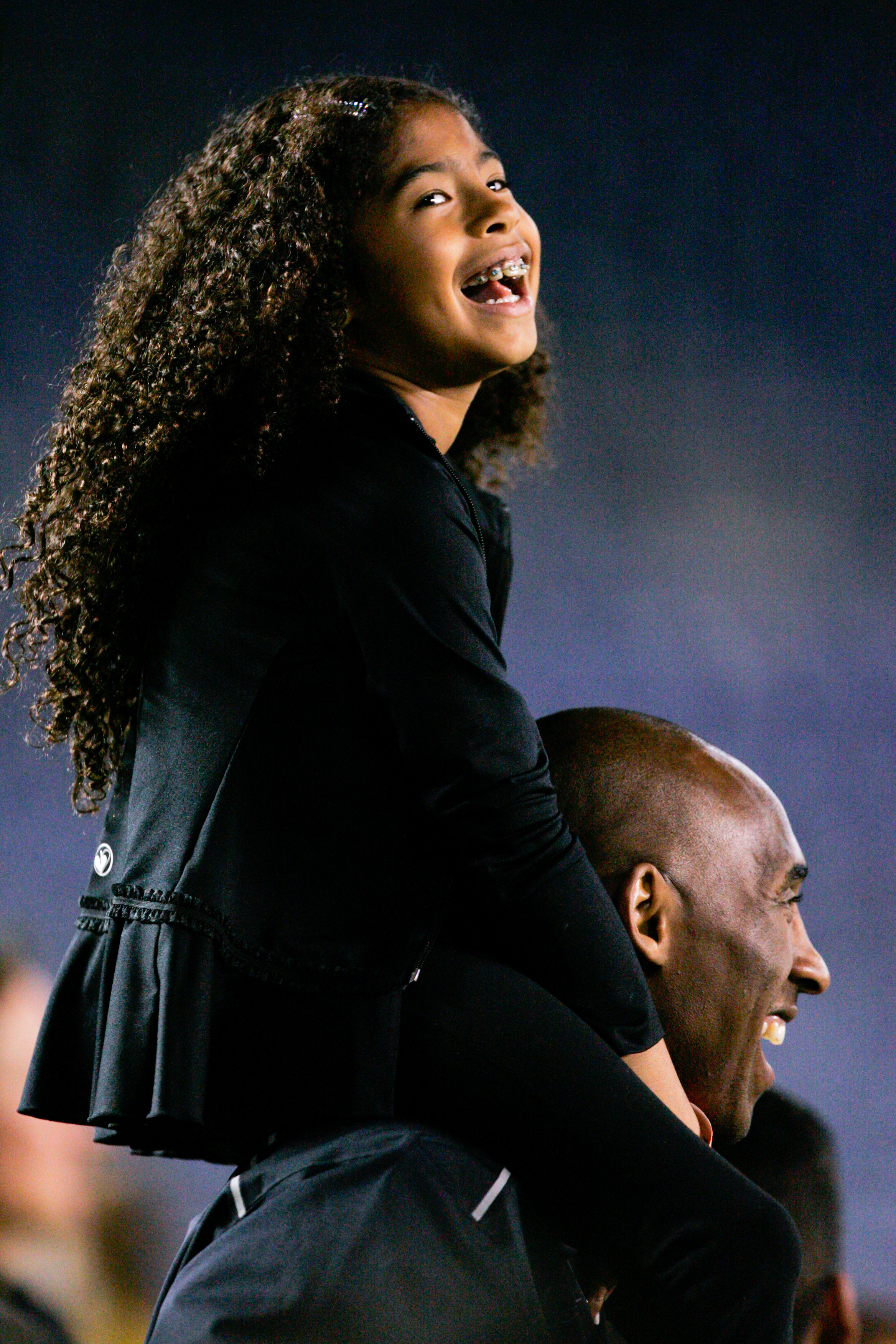 Kobe Bryant stands on the sideline with his daughter Gianna Maria-Onore Bryant on his shoulders at Qualcomm Stadium on April 10, 2014 | Source: Getty Images