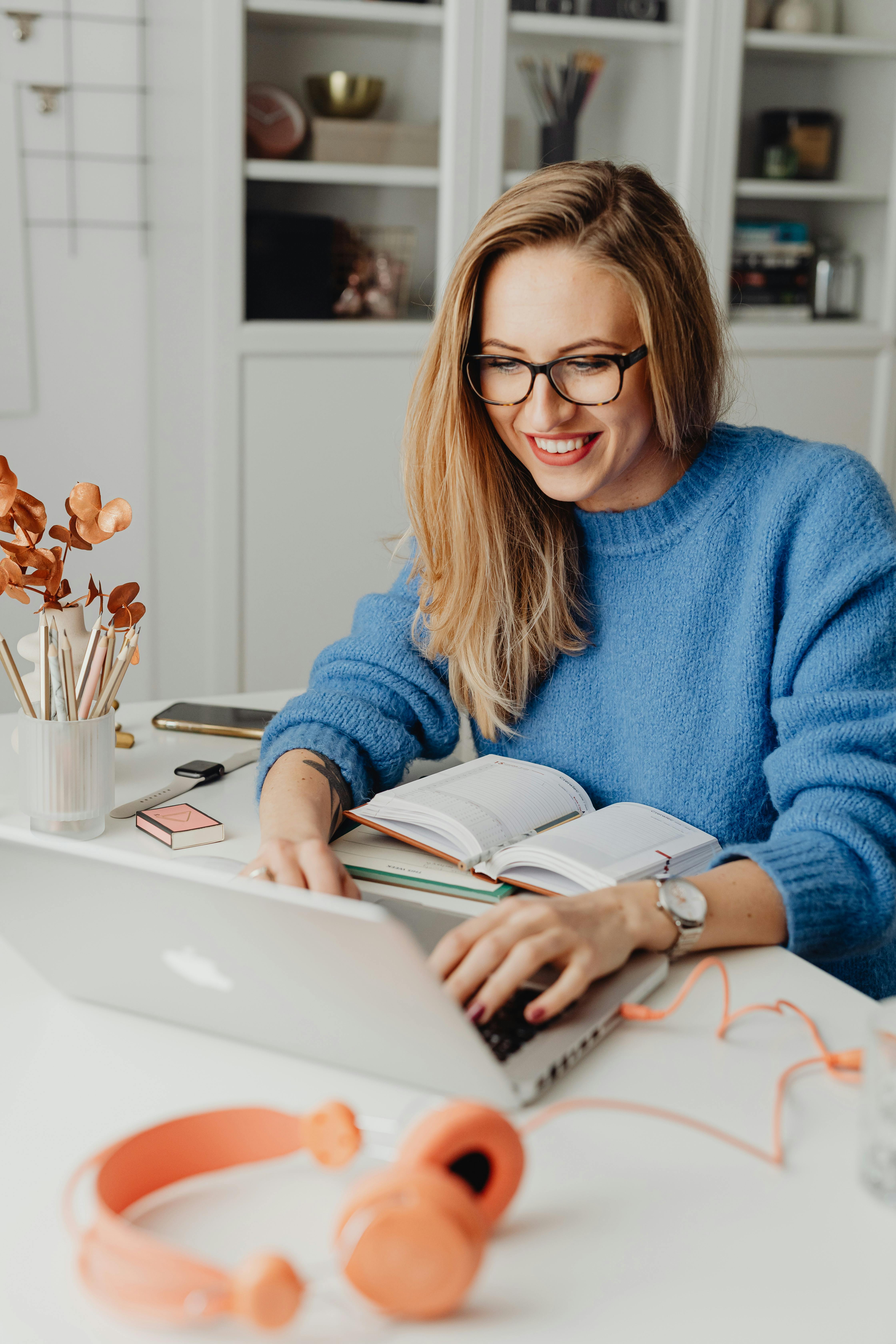 A happy woman using a laptop | Source: Pexels