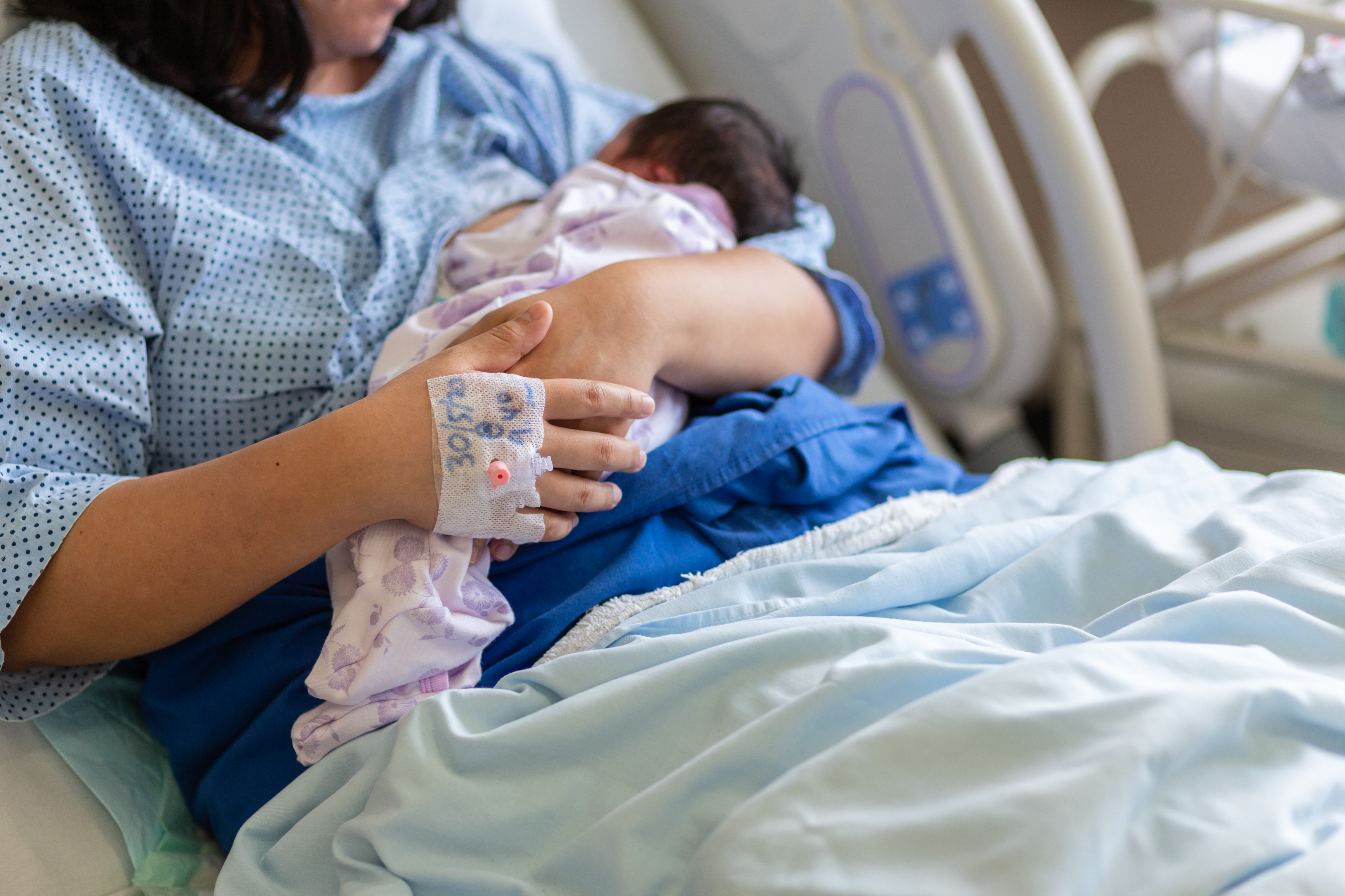 A woman cradling a newborn baby | Source: Shutterstock