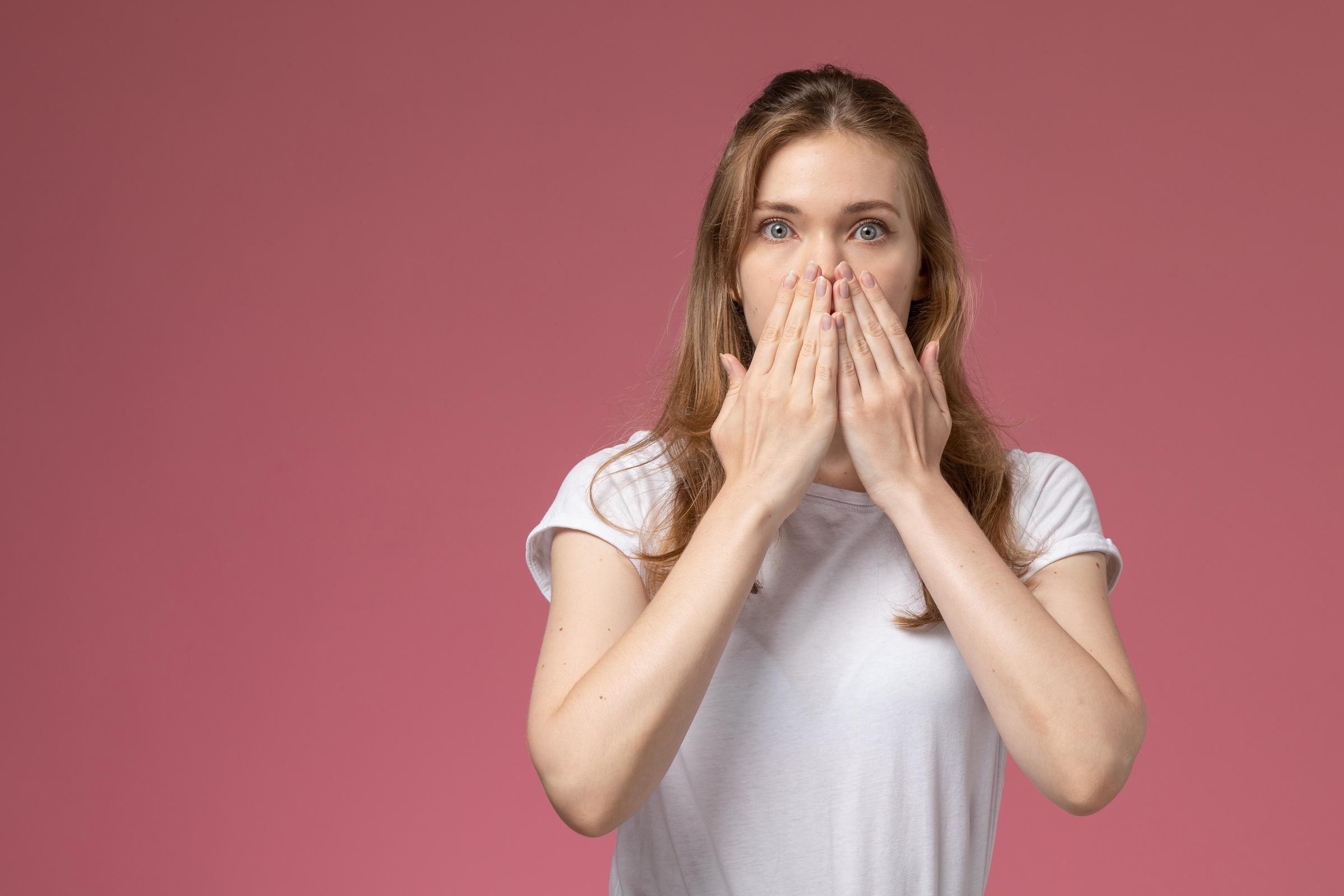 A stunned woman covering her mouth | Source: Freepik