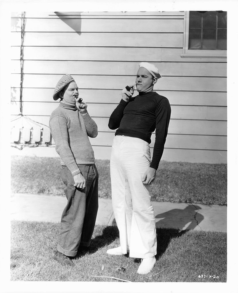 Cliff Edwards and William Haines holding pipes in a scene from the film 'Fast Life', 1932.| Source: Getty Images