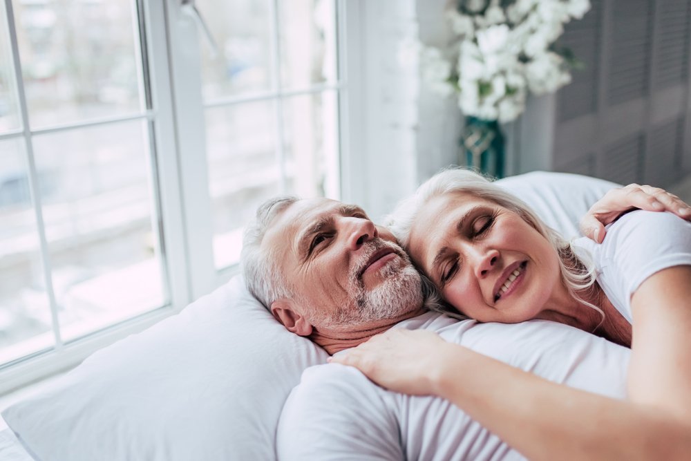 Elderly couple in bed together | Shutterstock