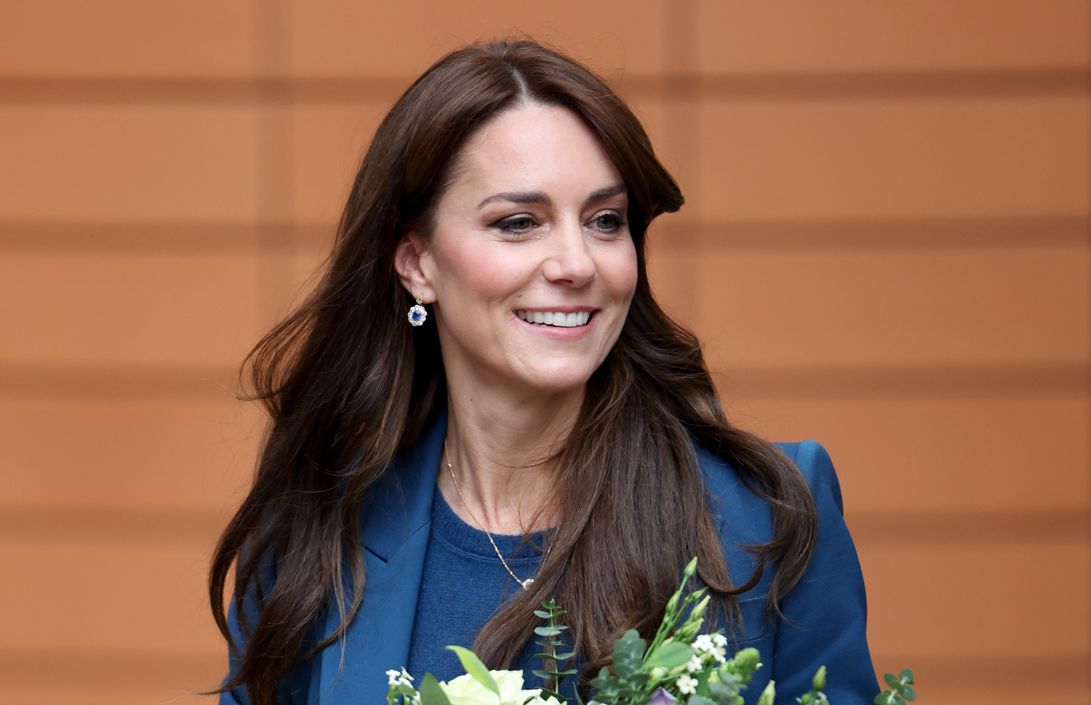 On December 5, 2023, Princess Catherine visits Evelina London's new children’s unit in a navy look; her chocolate-brown hair styled in a classic blowout with flipped ends and subtle volume.