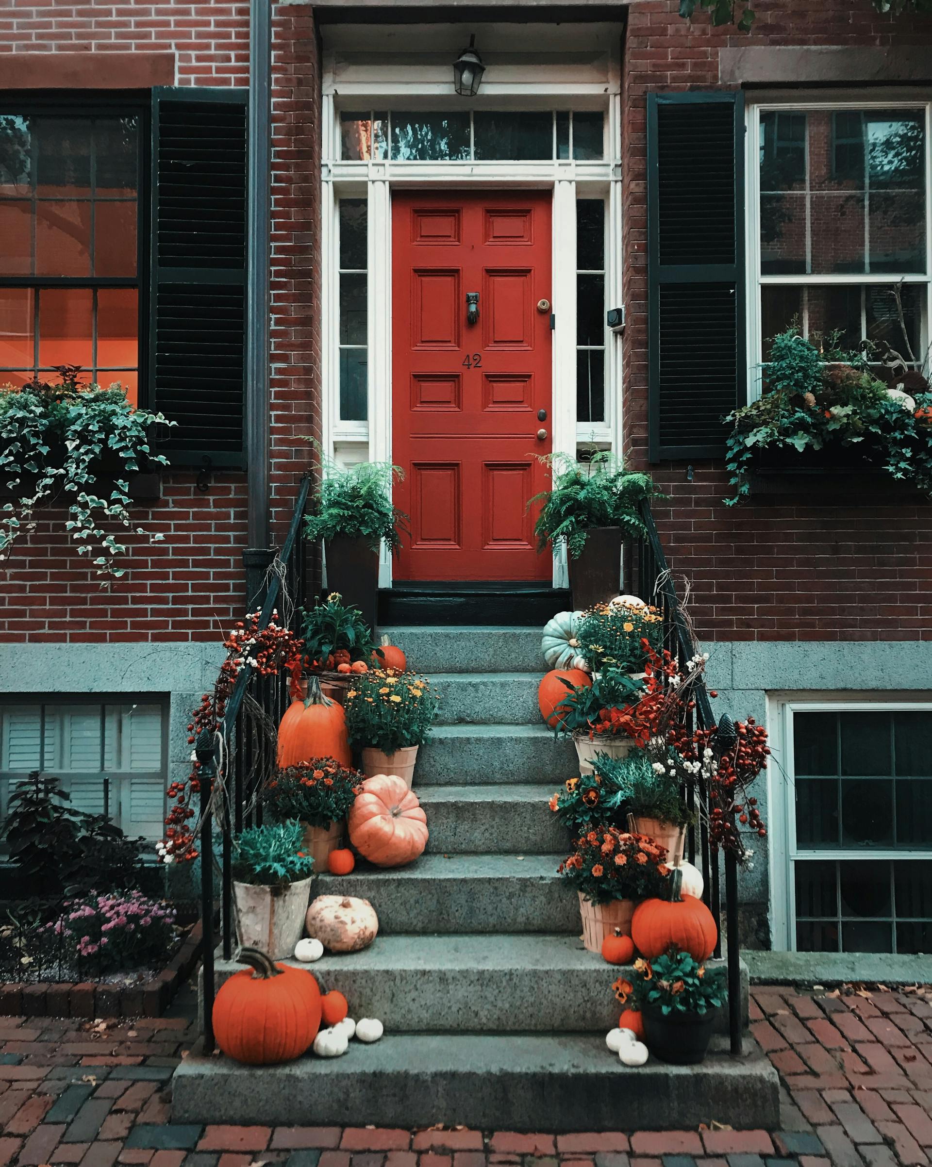 Pumpkins on the stairs in front of a door | Source: Pexels