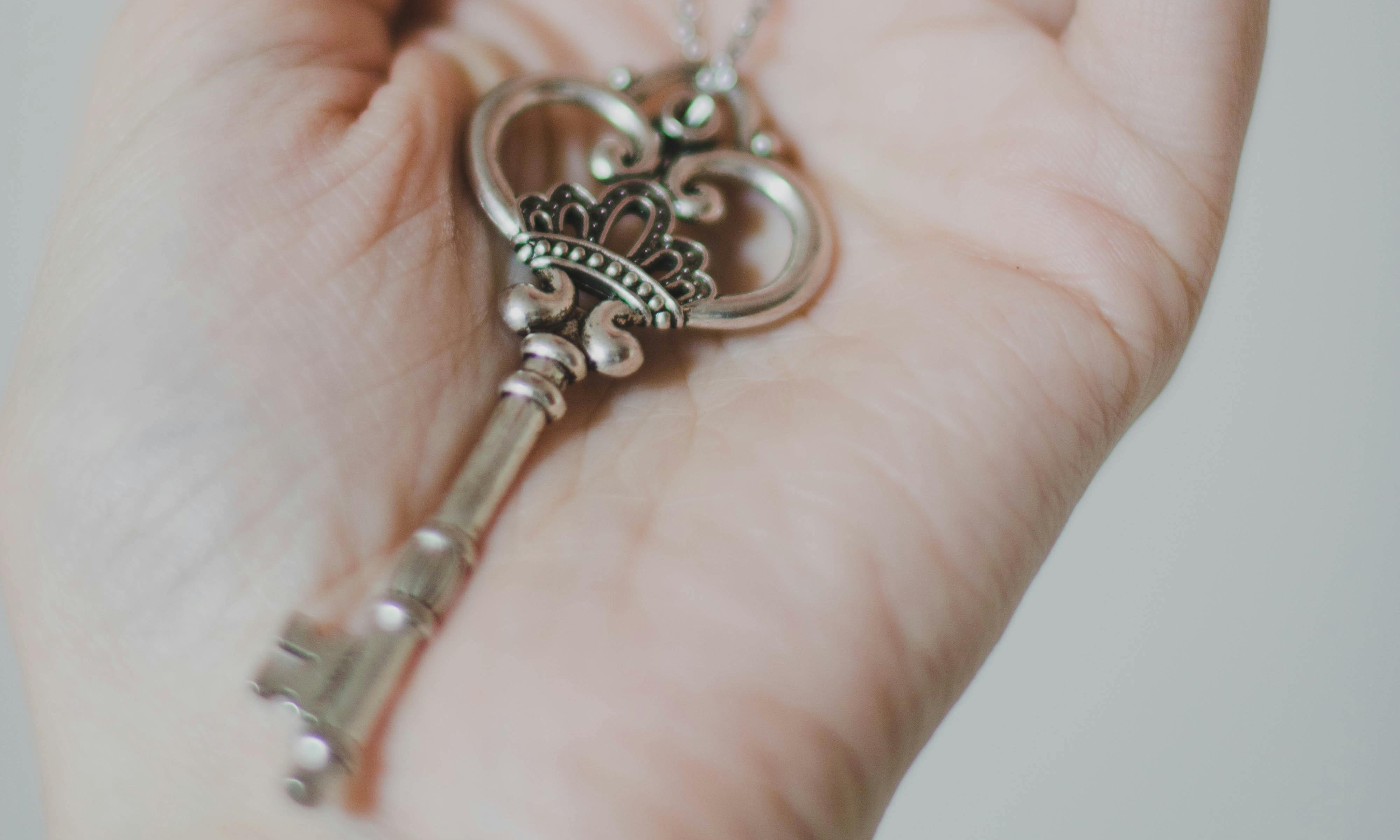 A small key in the palm of a hand | Source: Pexels