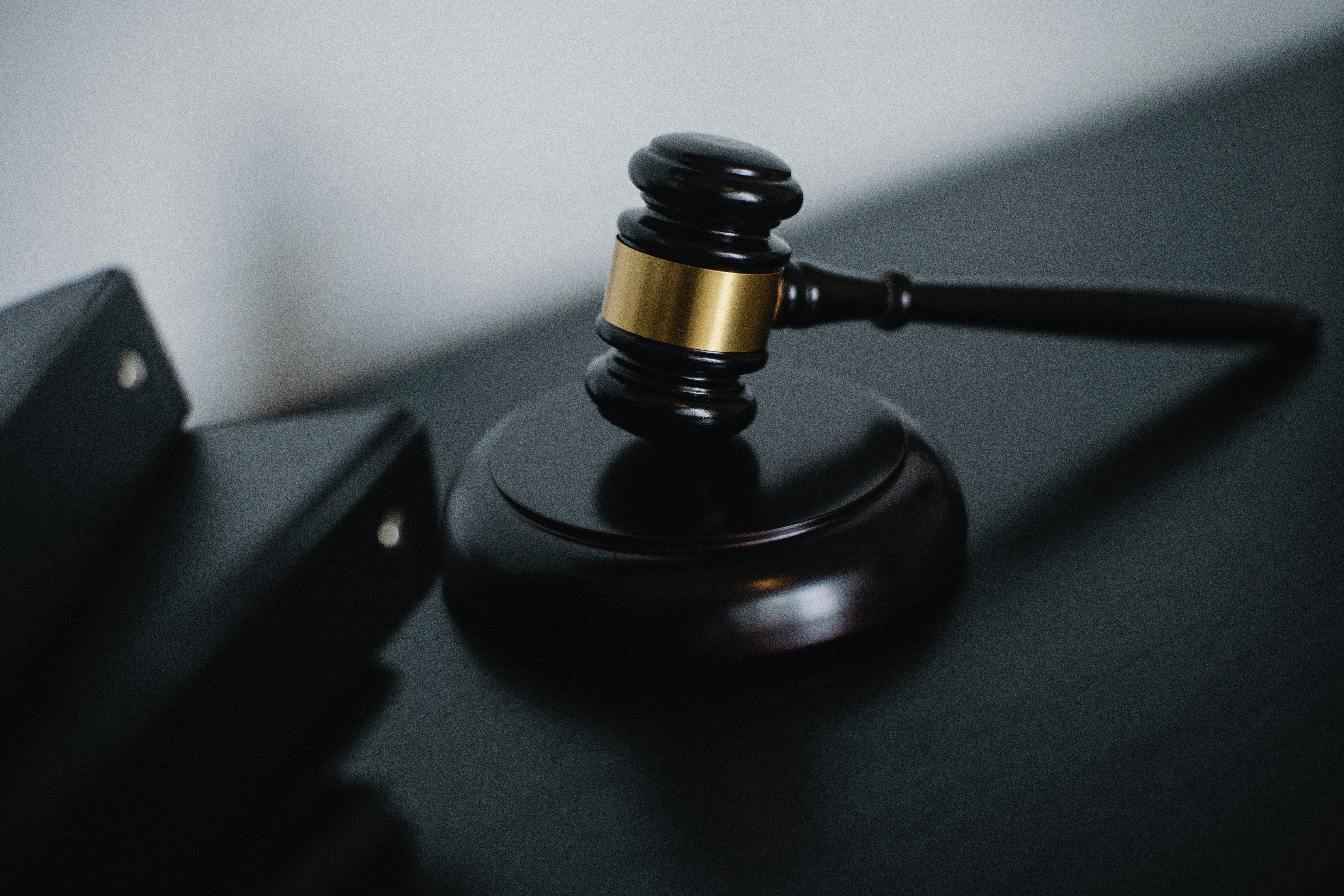 Pictured - A small judge gavel placed on the table near folders | Source: Pexels