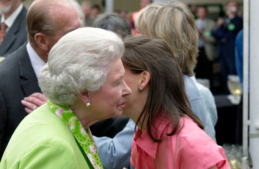 La reina Isabel II saluda a su sobrina, Lady Sarah Chatto, con un beso en la feria anual de flores de Chelsea, el 24 de mayo de 2004. | Foto: Getty Images