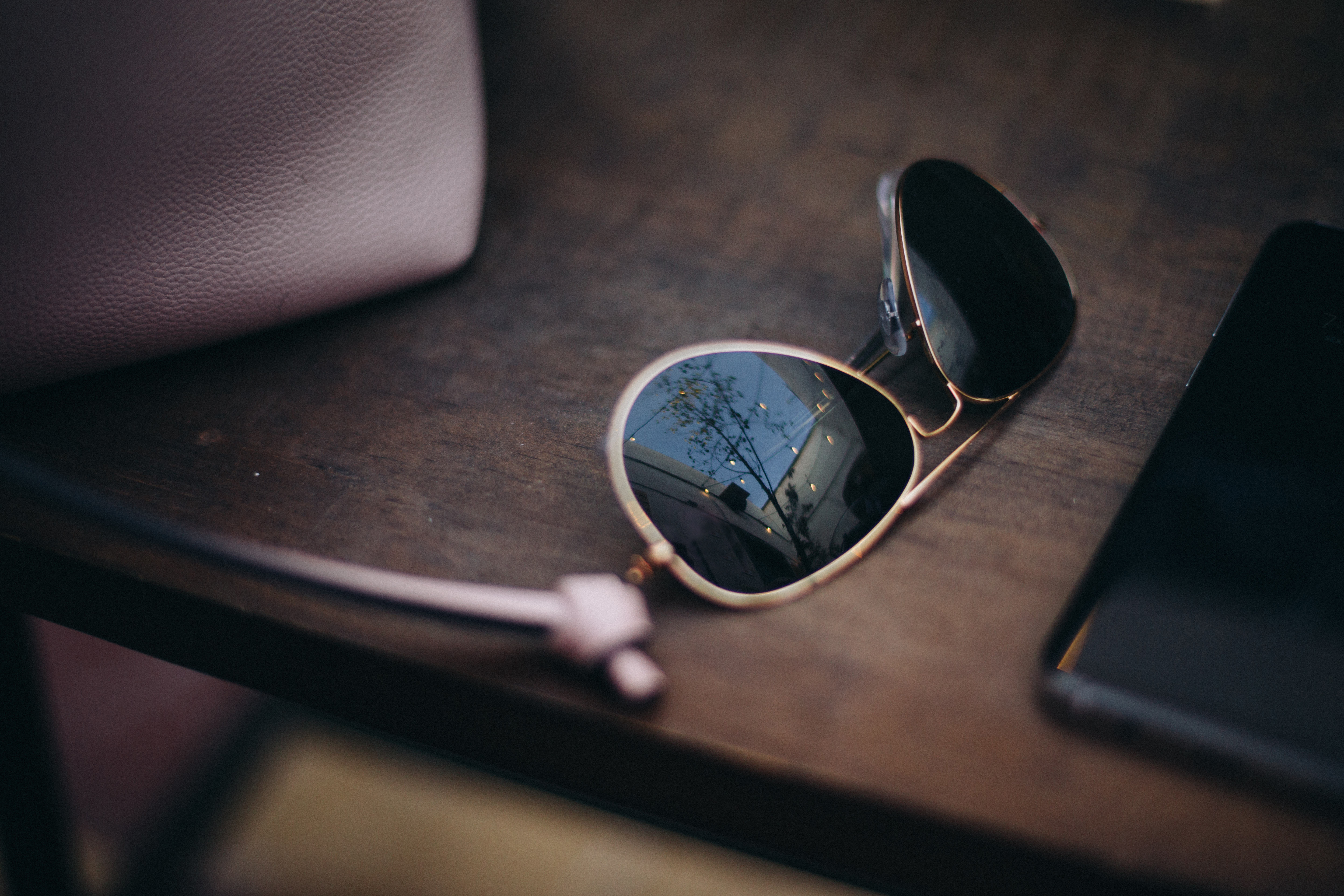 String lights reflected in sunglasses set on a wooden table | Source: Getty Images