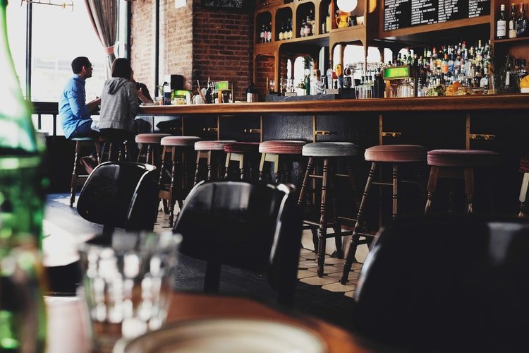 deux personnes assises sur une chaise de tabouret de bar devant la réception du bar. | Photo : Unsplash deux personnes assises sur une chaise de tabouret de bar devant la réception du bar. | Photo : Unsplash